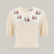A knitted cream jumper with half-length sleeves and small figures along the chest. There are four buttons at the neck on the back of the jumper to fasten.
