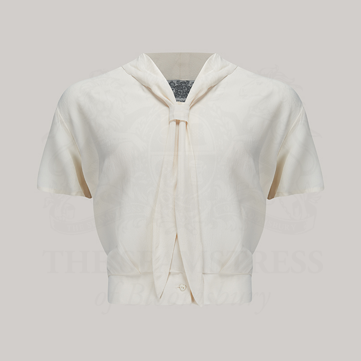 A 1940s sailor style blouse with short sleeves in cream. Featuring a roll style collar to give the iconic sailor look. Small buttons run down the front of the blouse for fastening but are hidden by the long collar.