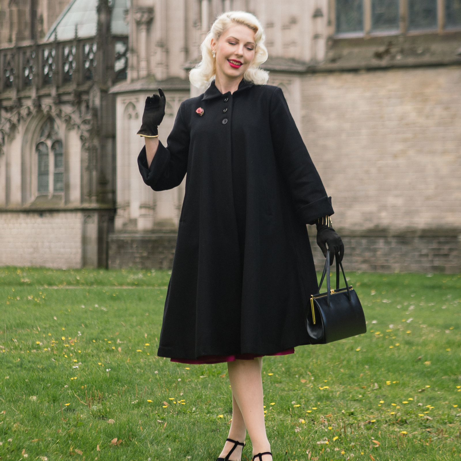 Woman in a black coat standing in front of a cathedral