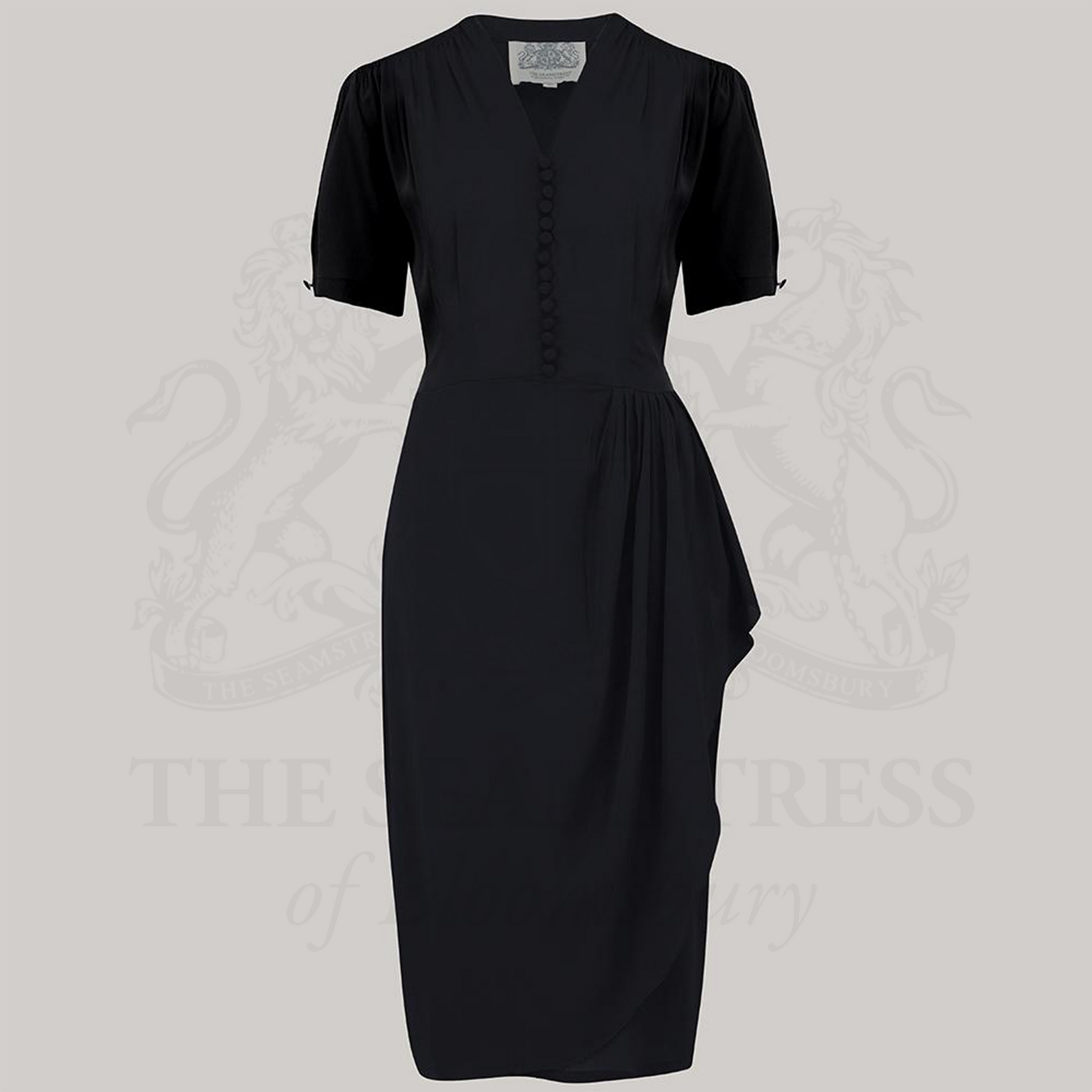 A black dress with a fitted style, featuring a waterfall ruffle on the waist, decorative buttons on the front bodice, and short sleeves.