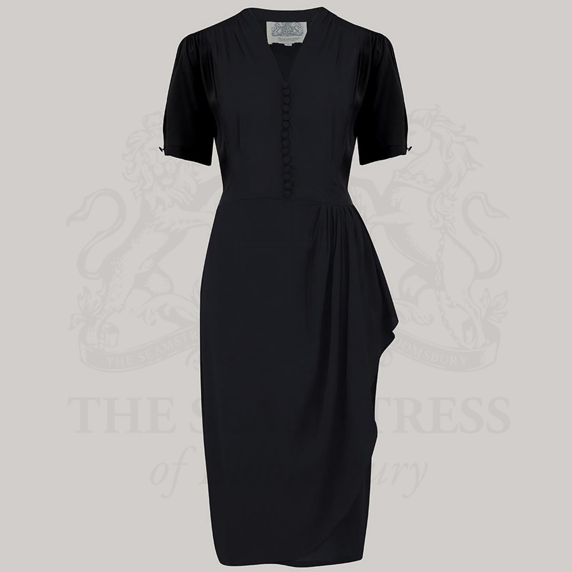 A black dress with a fitted style, featuring a waterfall ruffle on the waist, decorative buttons on the front bodice, and short sleeves.