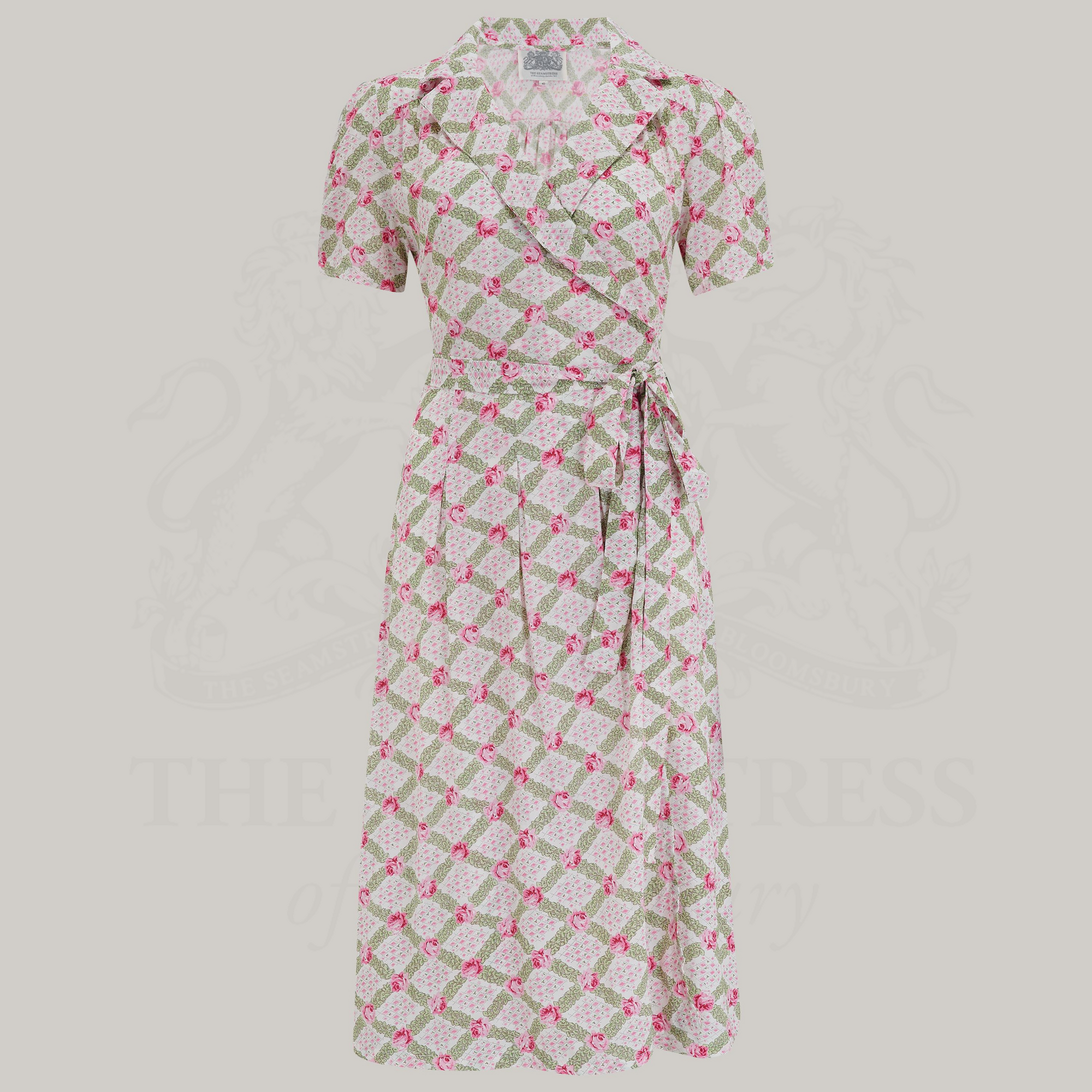 A floral v-neck dress with a tie at the waist, featuring box pleats at the waistband and side-seam pockets.
