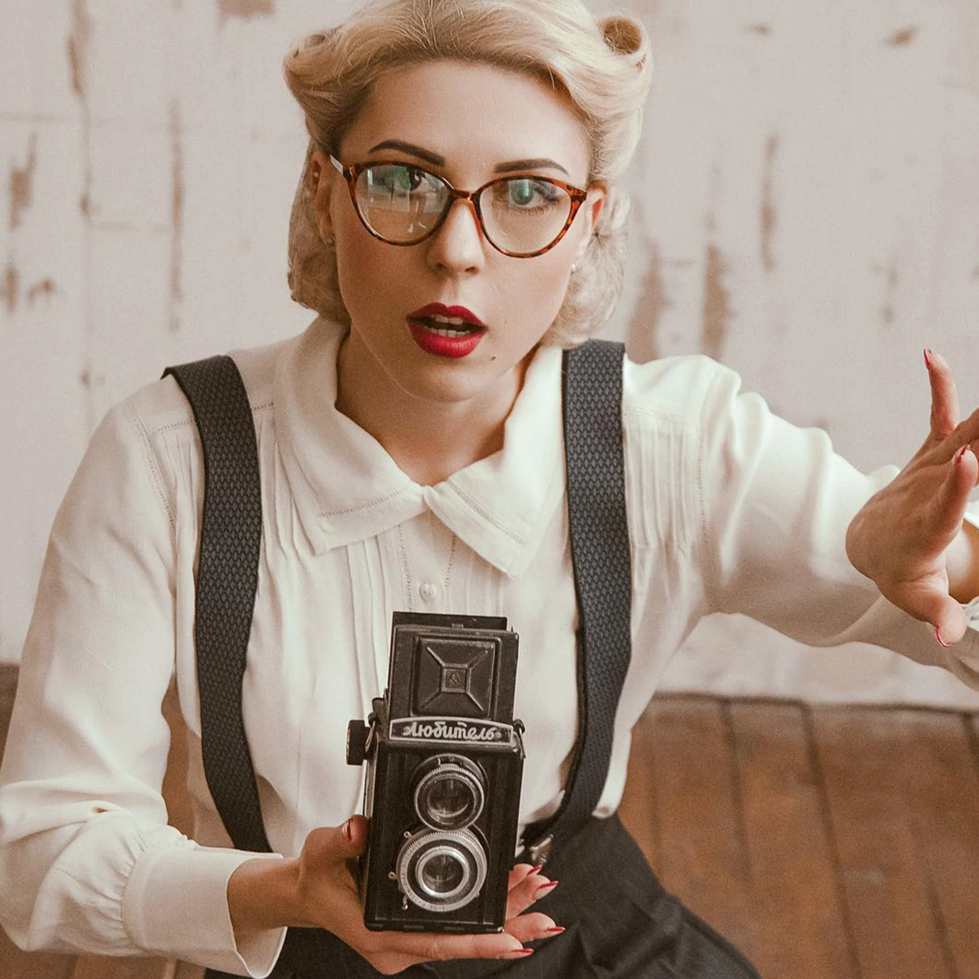 Model wears a 1940s style long sleeve cream blouse. The blouse has detailed pin tuck stitching, heart shaped buttons, and long sleeves.