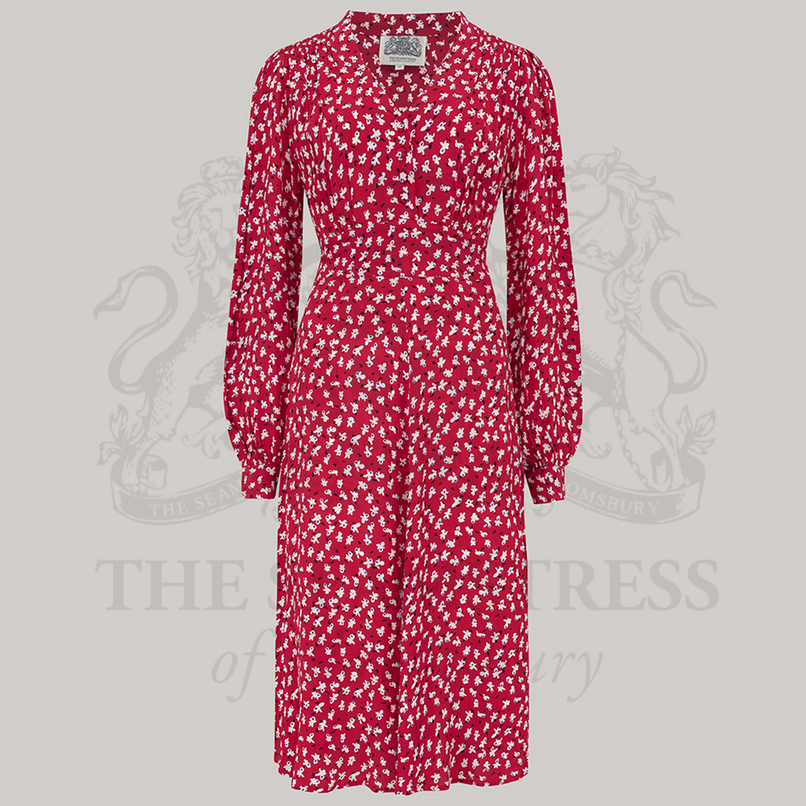 A 1940s style long sleeve dress in red with small clove patterns. Featuring gauged-in top yoke detailing on the shoulders. 4 small buttons on the bodice, and a tie-waist belt.