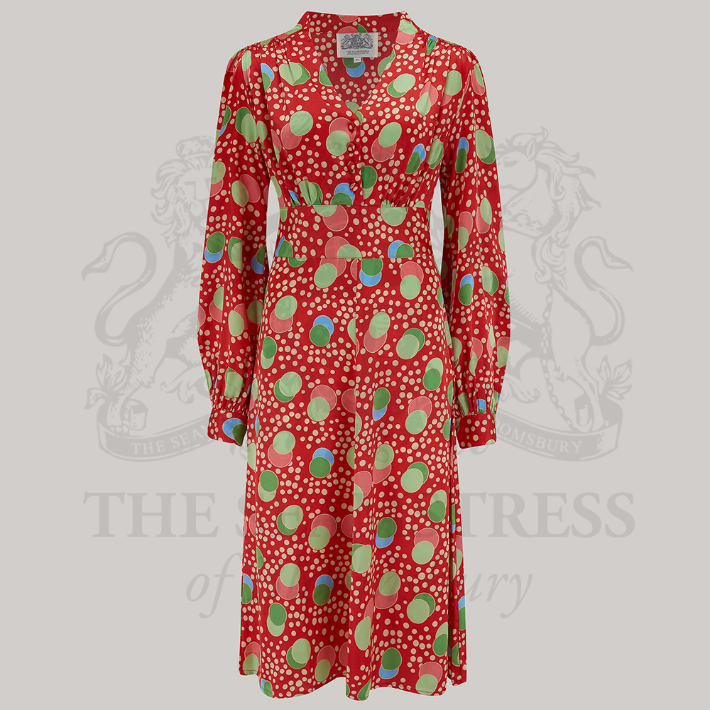 A 1940s style long sleeve dress in atomic inspired print. Featuring gauged-in top yoke detailing on the shoulders and sleeves that puff out fully at the cuff. 