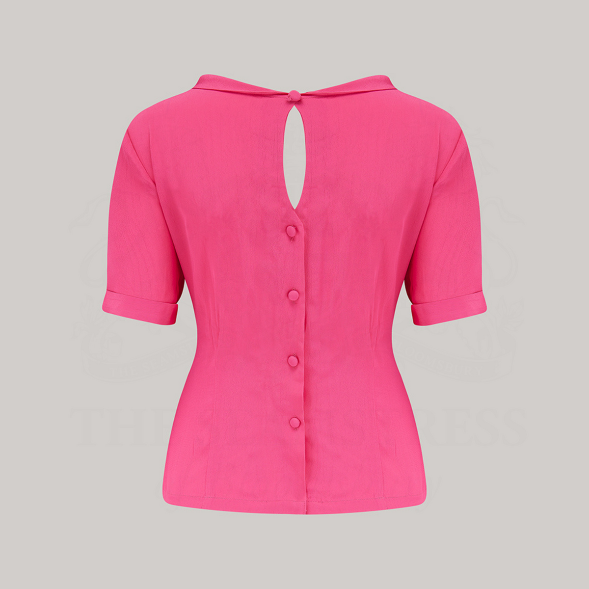 A 1940s-style short-sleeved raspberry pink blouse. Featuring a side tie-neck collar and button fastenings down the back of the blouse.