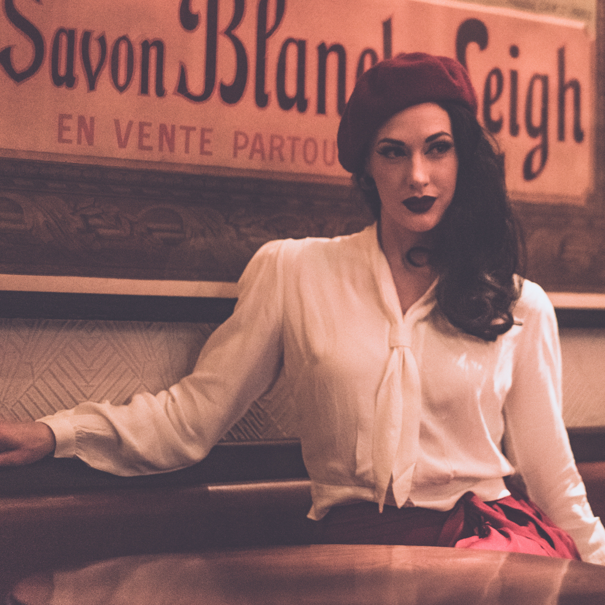 Model wears a 1940s sailor style blouse with long sleeves in cream with a burgundy coloured skirt and matching coloured beret with dark red lipstick. Featuring a roll style collar to give the iconic sailor look. Small buttons run down the front of the blouse for fastening but are hidden by the long collar.