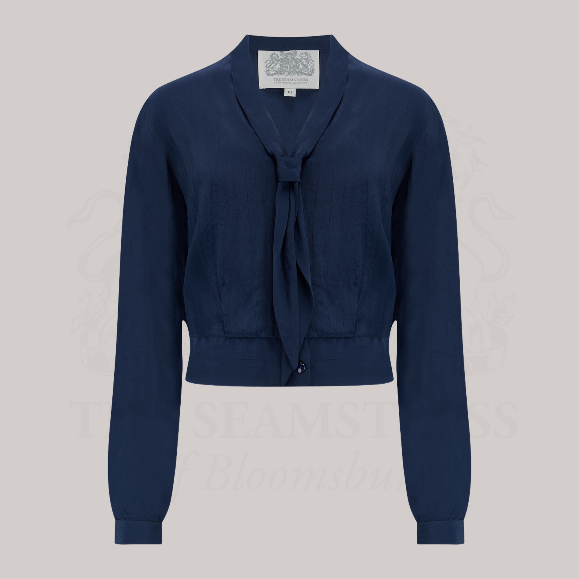 A 1940s sailor-style blouse in navy blue. Featuring a roll-style sailor collar. Small buttons run down the front of the blouse for fastening but are hidden by the long collar.