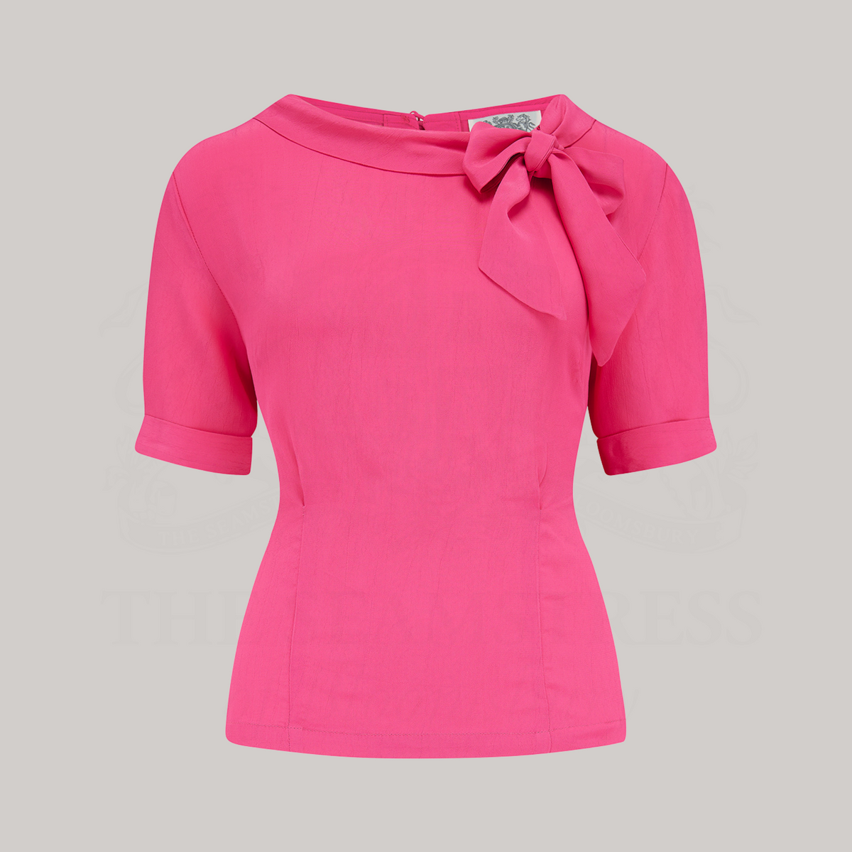 A 1940s-style short-sleeved raspberry pink blouse. Featuring a side tie-neck collar and button fastenings down the back of the blouse.