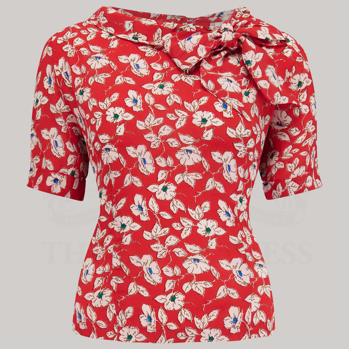 A 1940s-style short-sleeved red floral blouse. Featuring a side tie-neck collar and button fastenings down the back of the blouse.