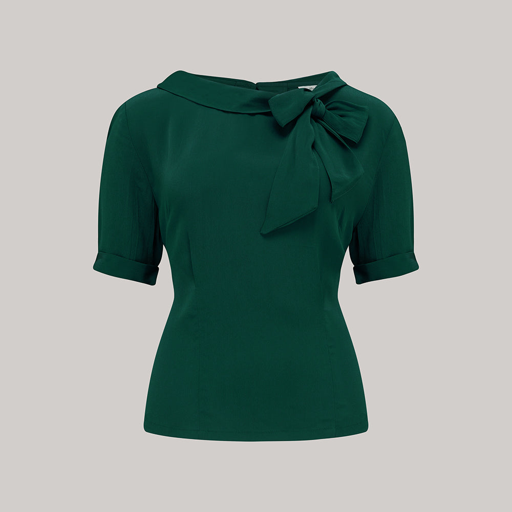 A 1940s style short sleeve dark green blouse. Featuring a side tie-neck collar and button fastenings down the back of the blouse.