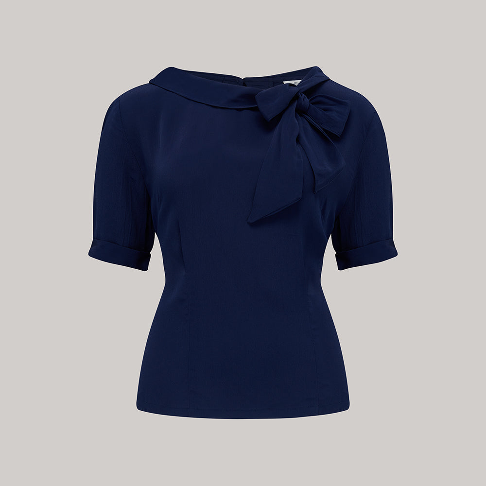 A 1940s style short sleeve navy blue blouse. Featuring a side tie-neck collar and button fastenings down the back of the blouse.