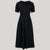 A 1940s vintage style short sleeve dress with a side tie-neck and a tie-waist belt. This dress is in a black colour and has a a-line skirt and is designed to finish below the knee.