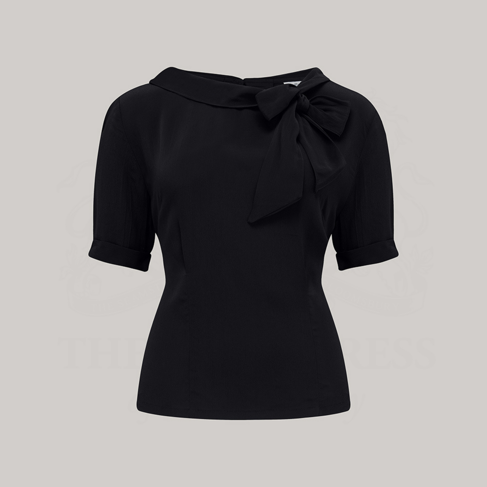 A 1940s style short sleeve black blouse. Featuring a side tie-neck collar and button fastenings down the back of the blouse.
