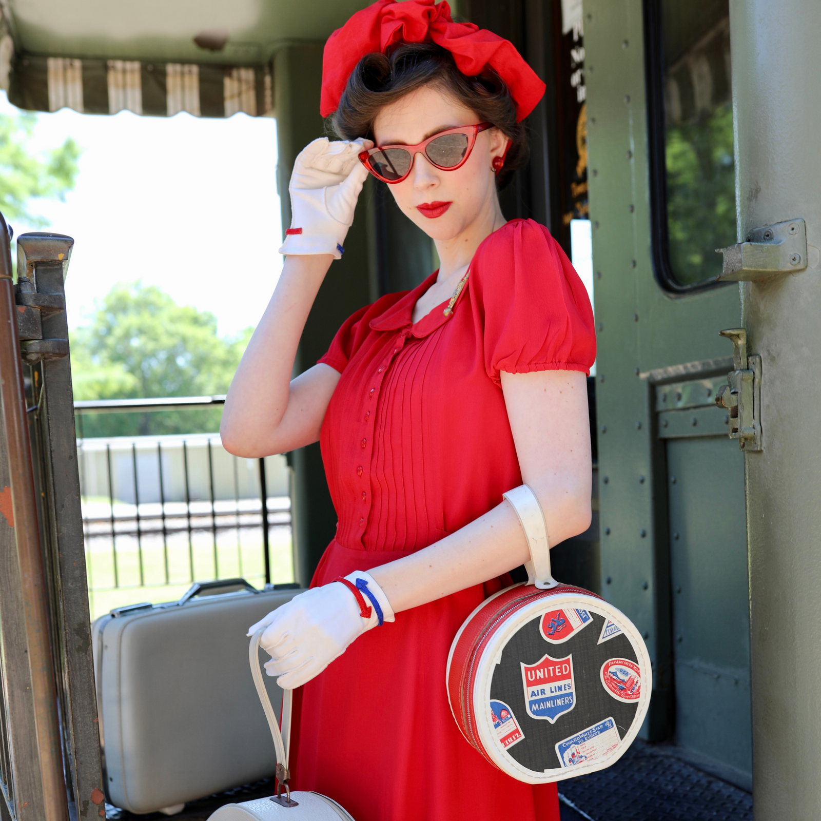 Model wears a 1940s-inspired red dress with pin tuck detailing on the bodice 