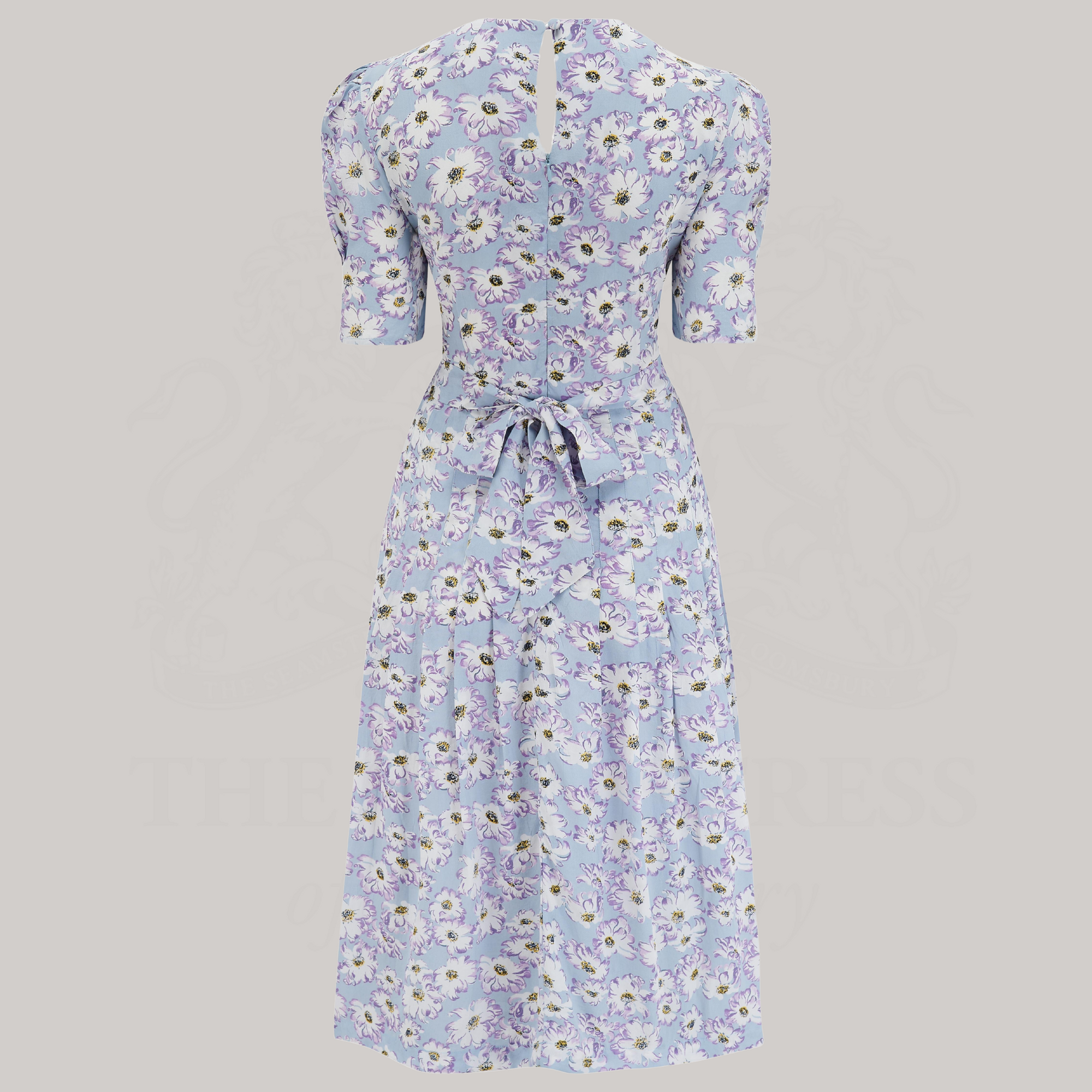 A 1940s-style short-sleeve dress in pale blue with floral design. Featuring a sweetheart neckline, smocking detailing, pockets, and a waist tie.