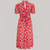 a 1940s-style swing dance dress in red with a cream floral pattern with a tie-waist back belt