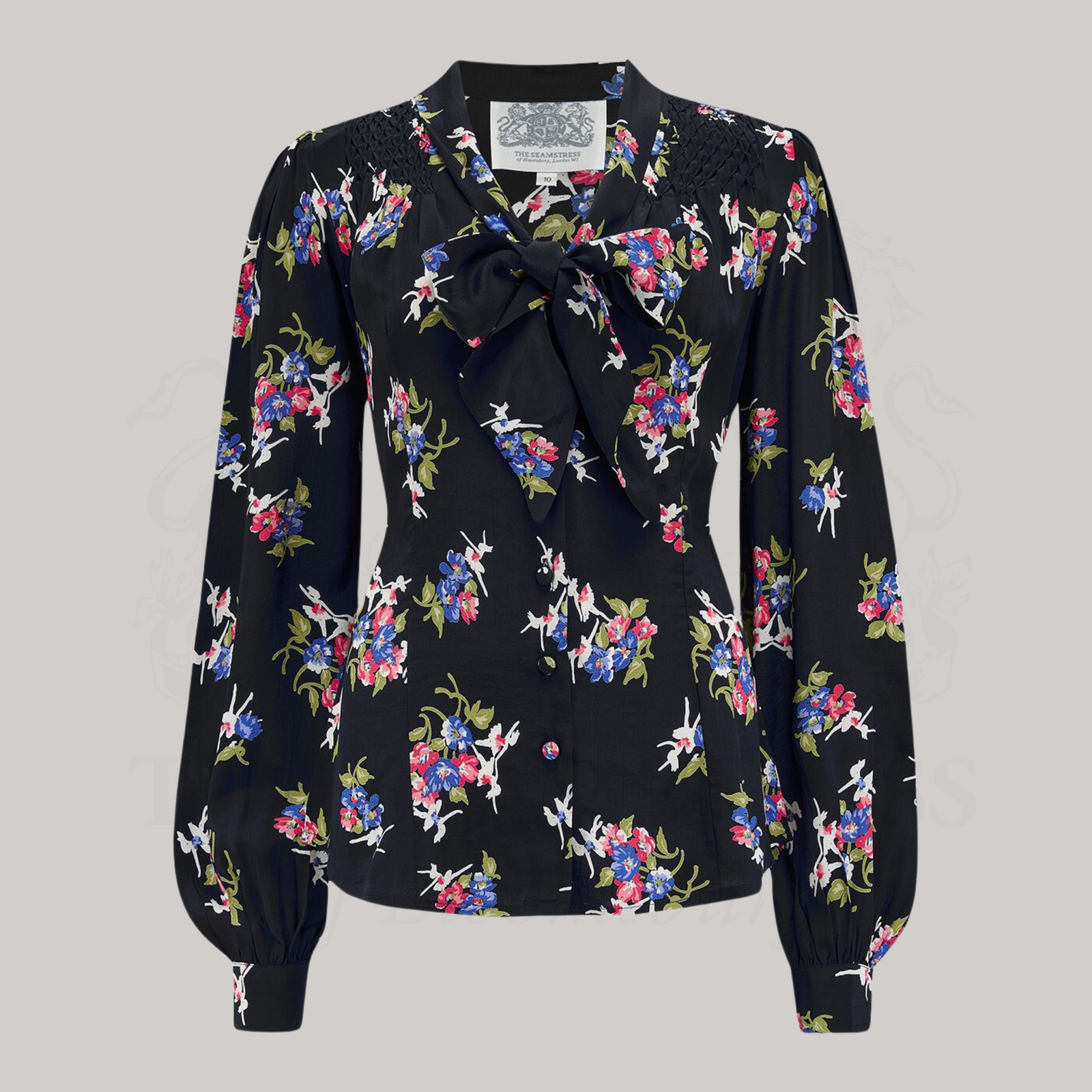 A black floral pussy bow blouse with long bishop sleeves and button fastenings.
