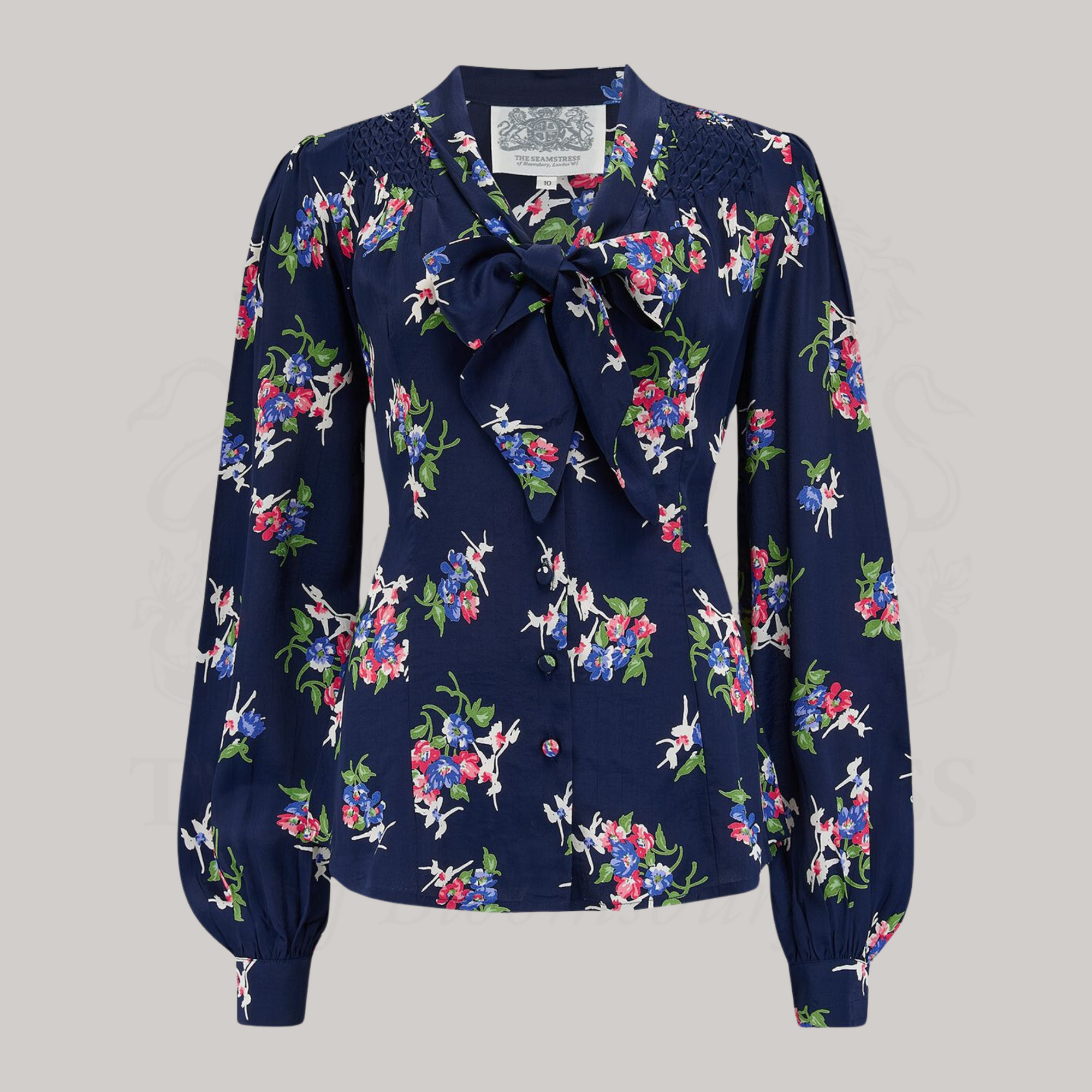 A navy floral dancer blouse with a pussy-bow neckline, long bishop sleeves with full cuffs, and smock stitching on the shoulders. 