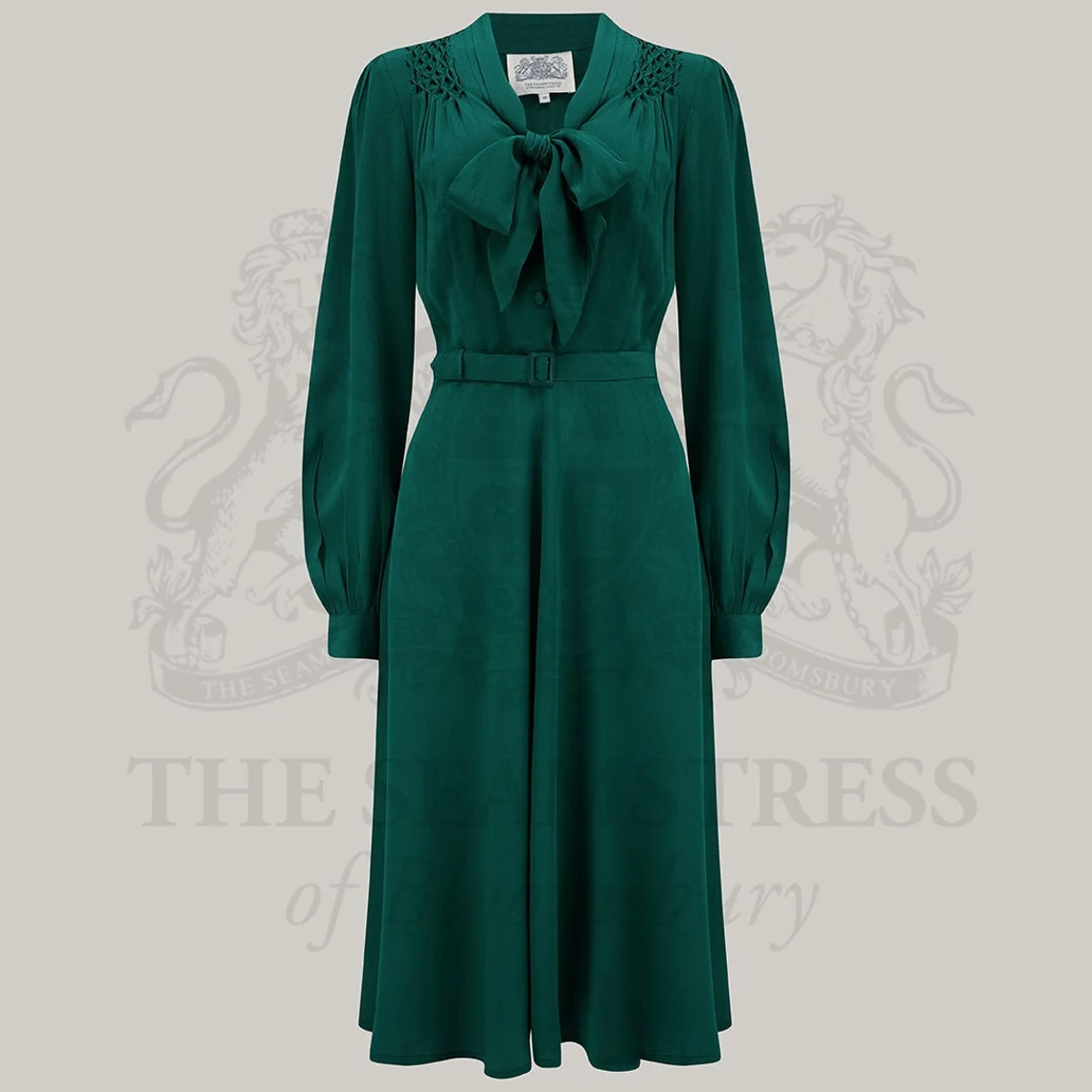 A vintage-inspired green dress with a pussy-bow neckline and long sleeves