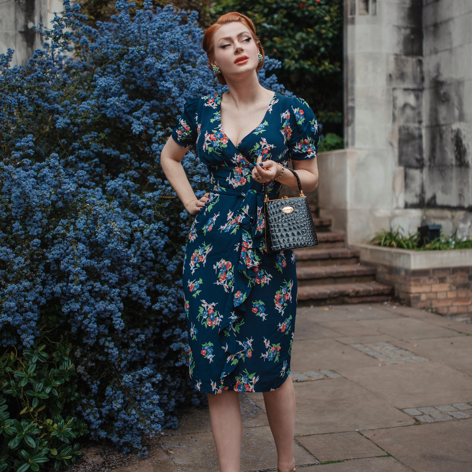 a model wearing a 1940s style navy floral dress