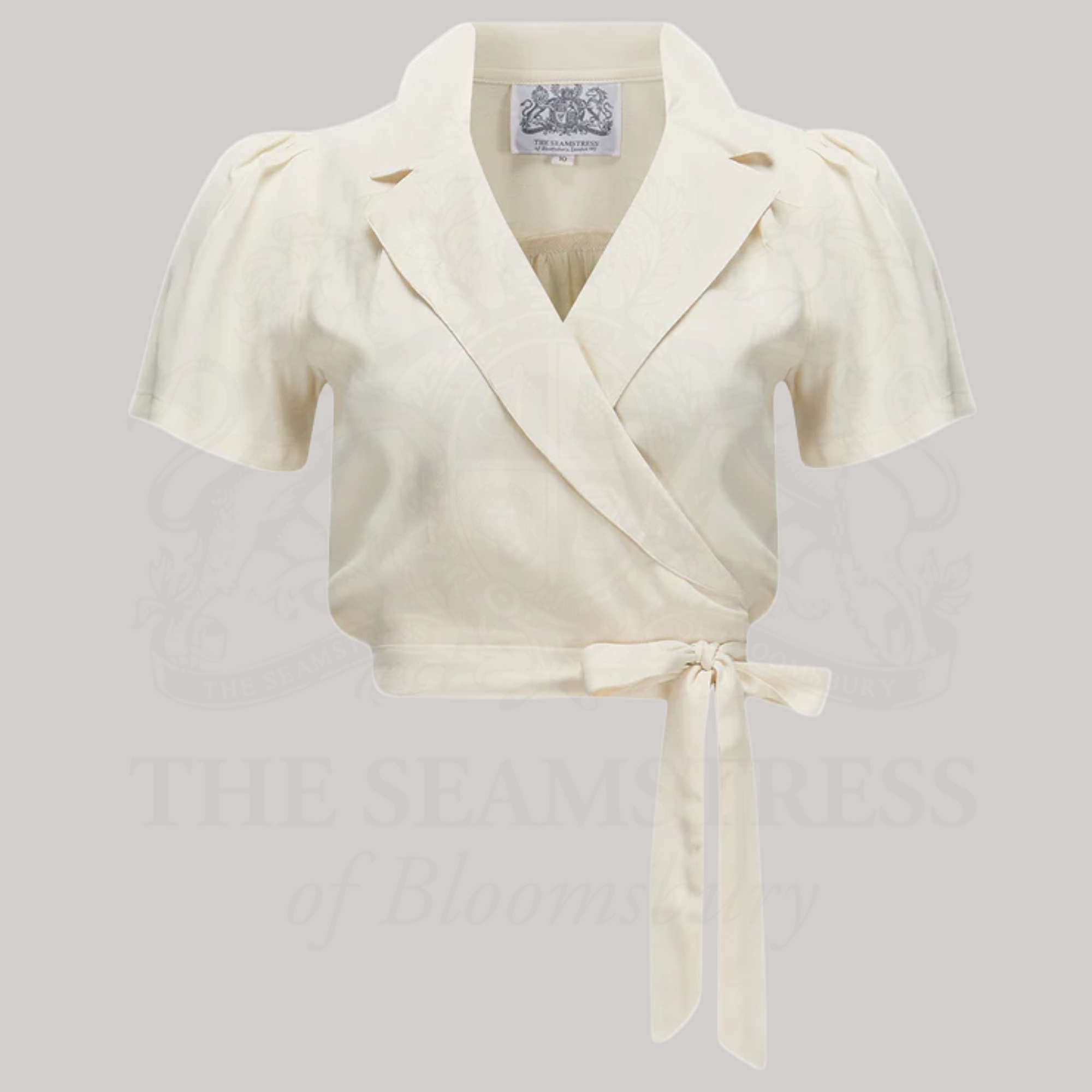 A cream-colored wrap blouse with short sleeves and a revere collar
