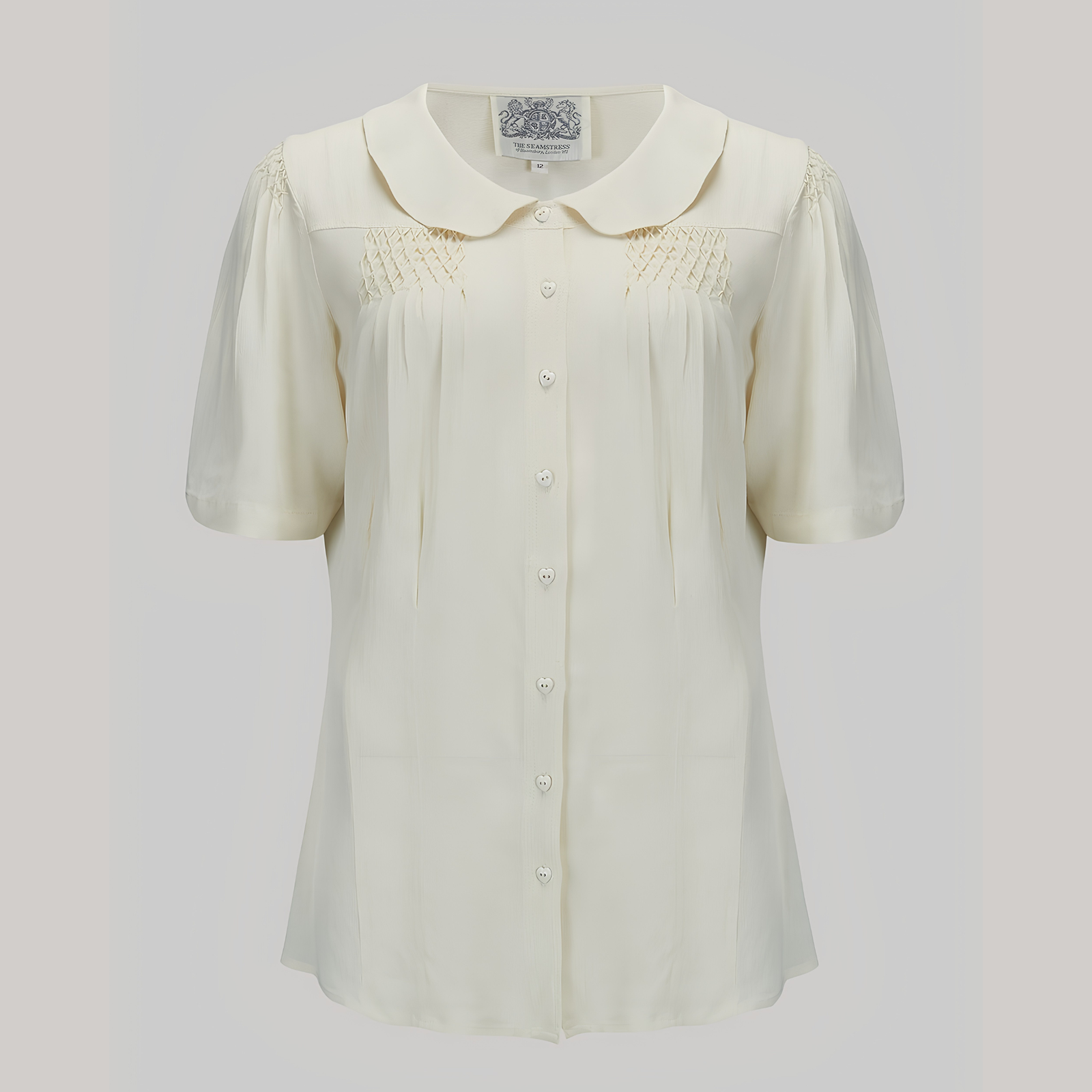 White blouse with short sleeves on a light gray background