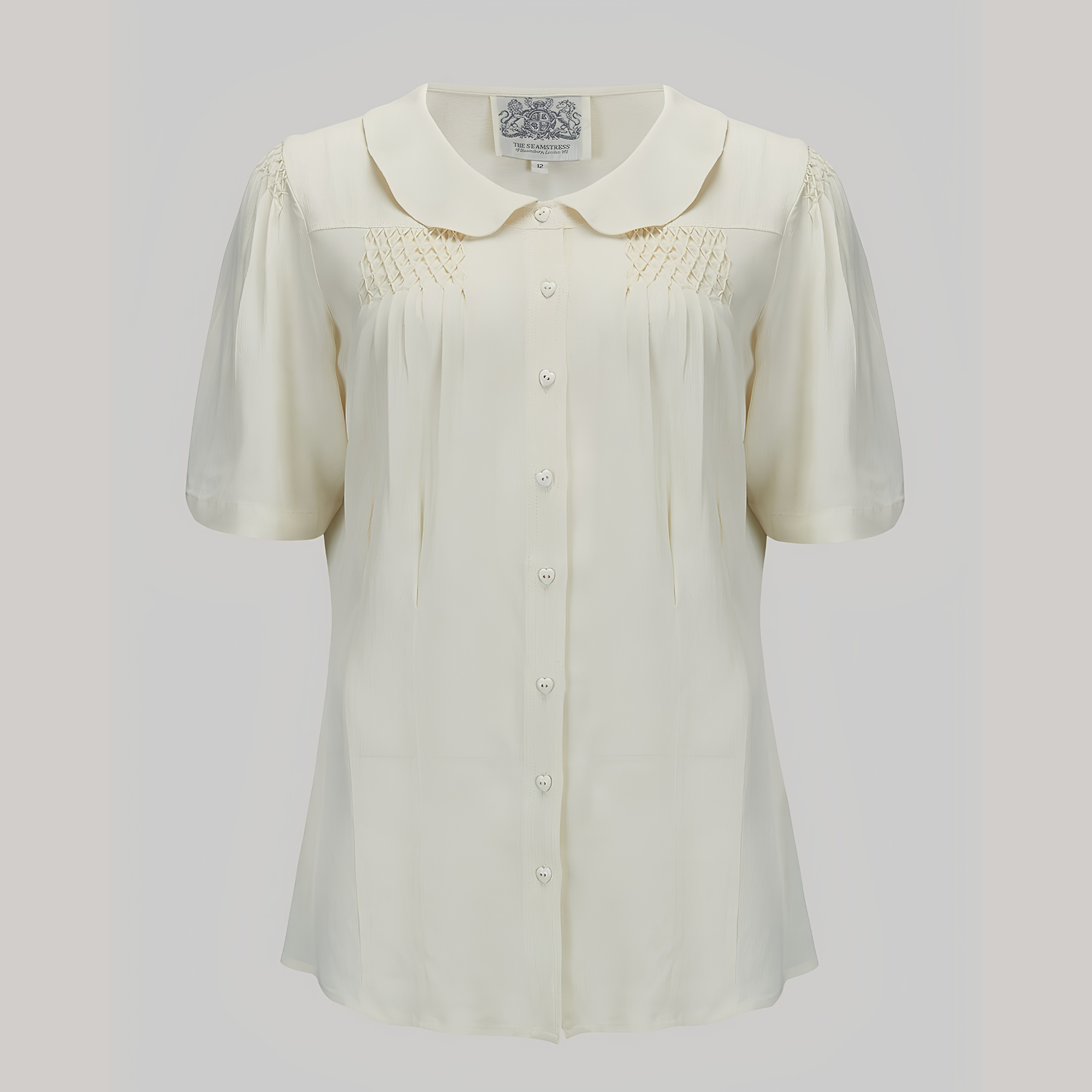 White blouse with short sleeves on a light gray background