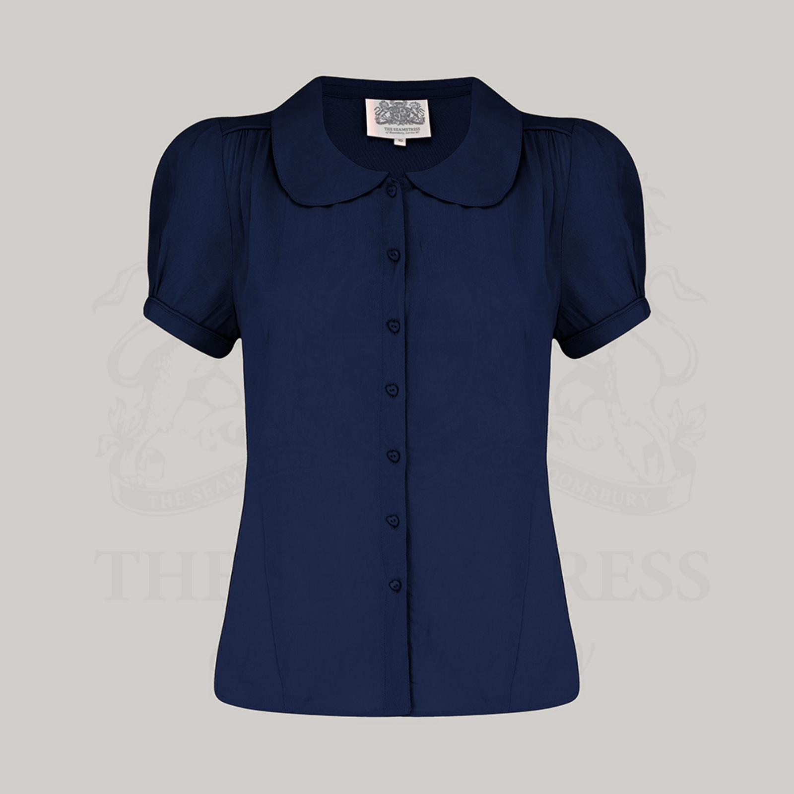 A navy short-sleeved blouse with a Peter Pan collar and puff sleeves, displayed against a white background.