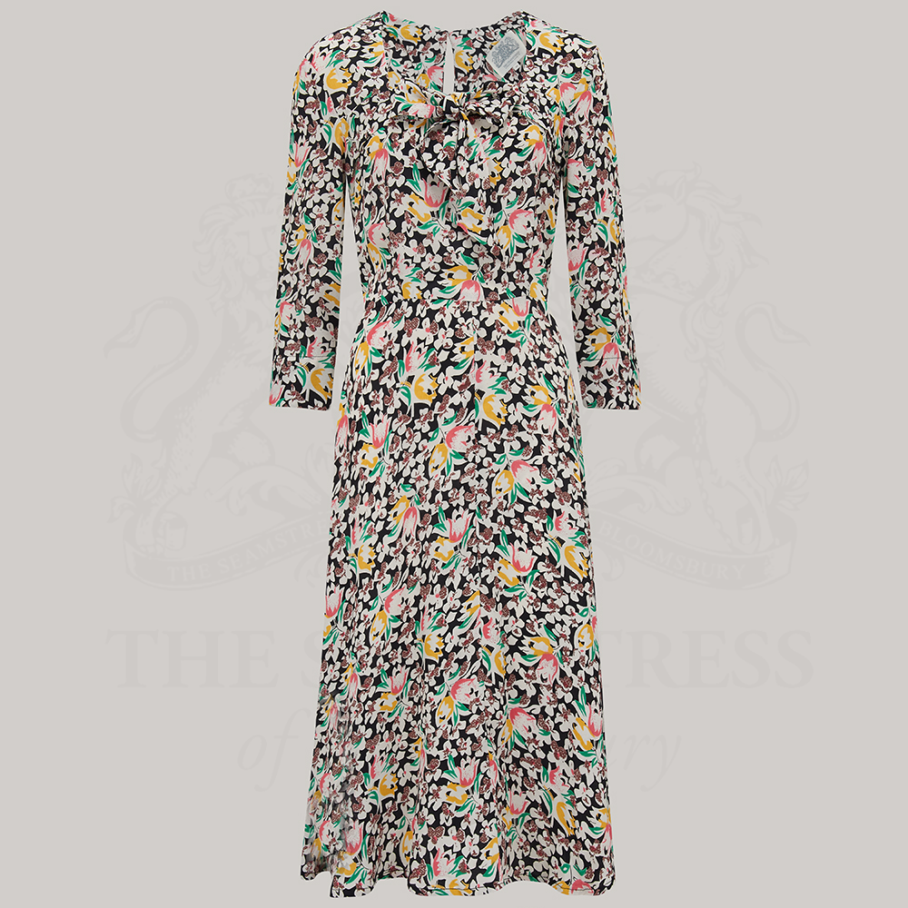 A long sleeve Joyce dress featuring a tulip print, with a sweetheart neckline and a center front pussy bow.