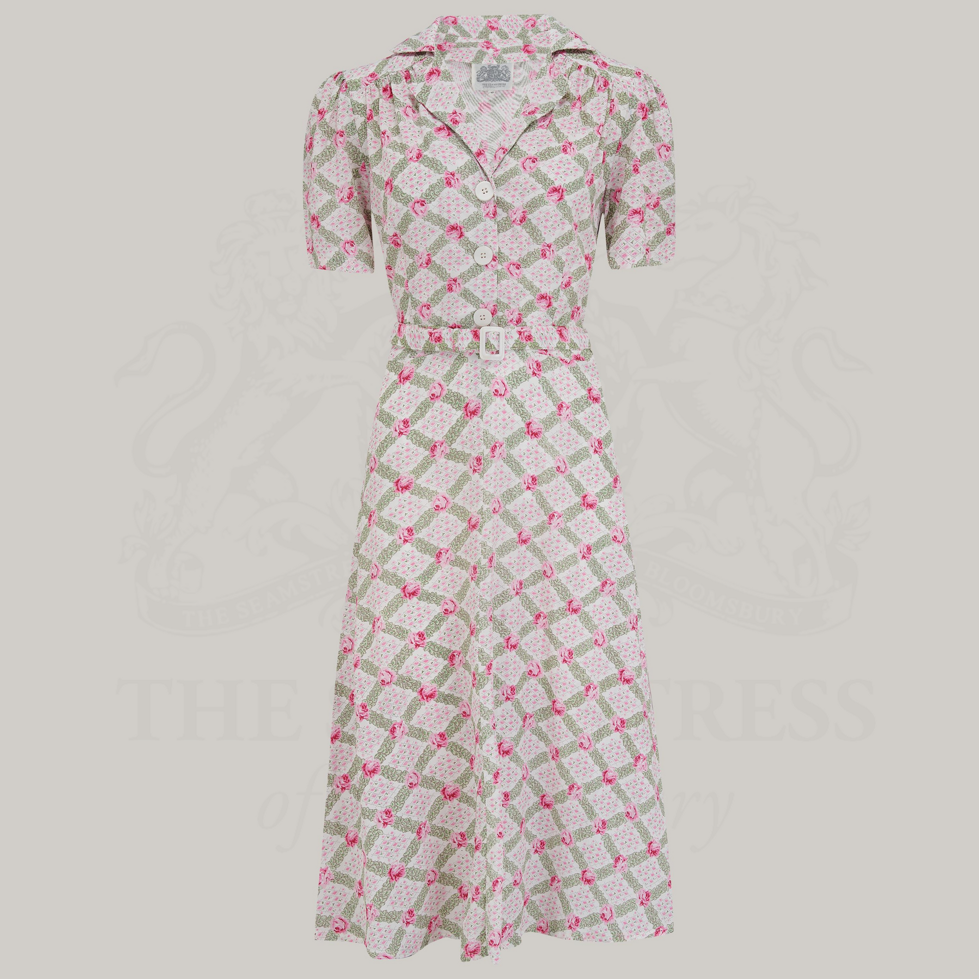 A rose kiss print shirtwaister dress with a tailored silhouette, button-down bodice, and side-seam pockets. 