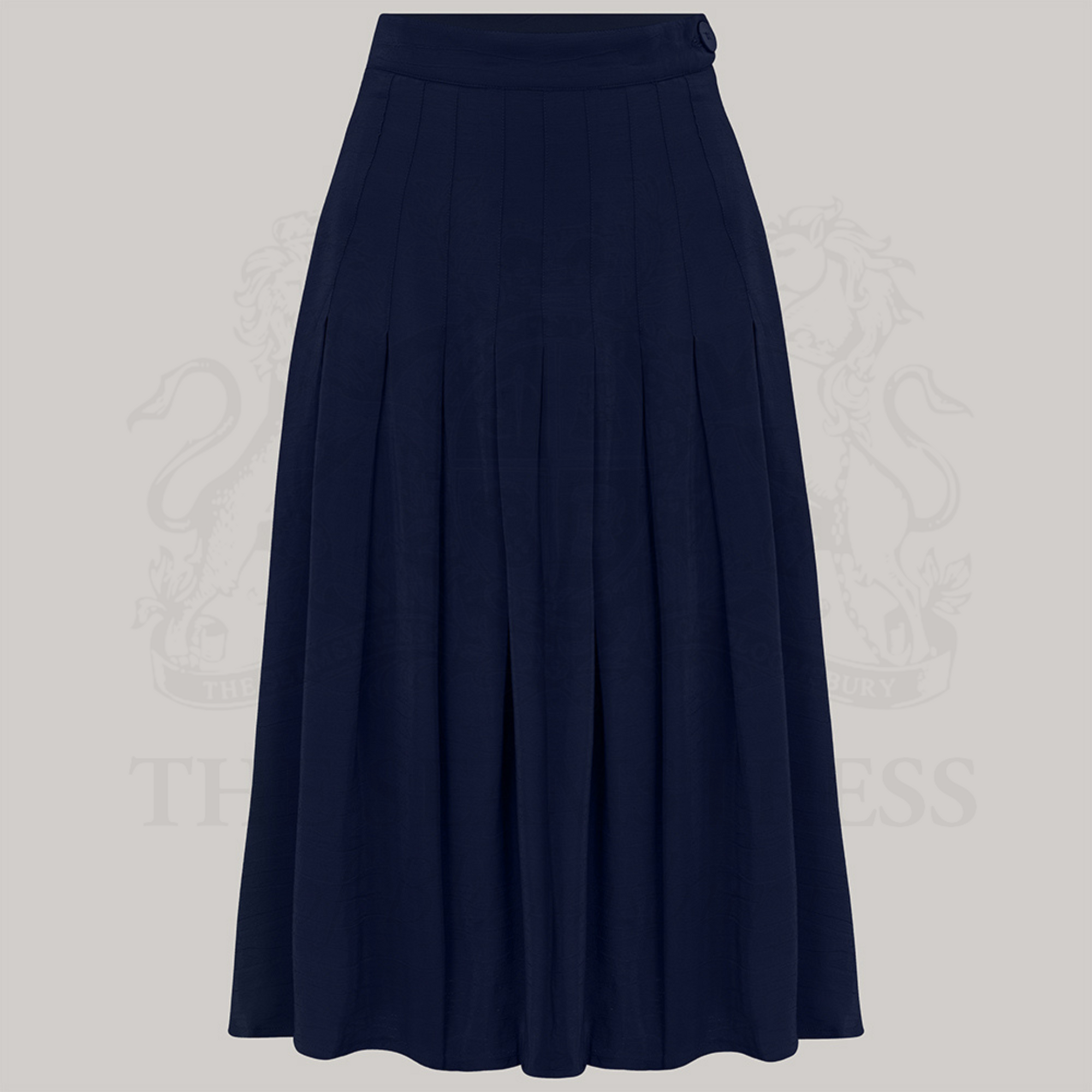 A pleated skirt in French Navy color with pin-stitched inverted pleats and a large bakelite-style button on the waist, made from Crepe de Chine fabric.
