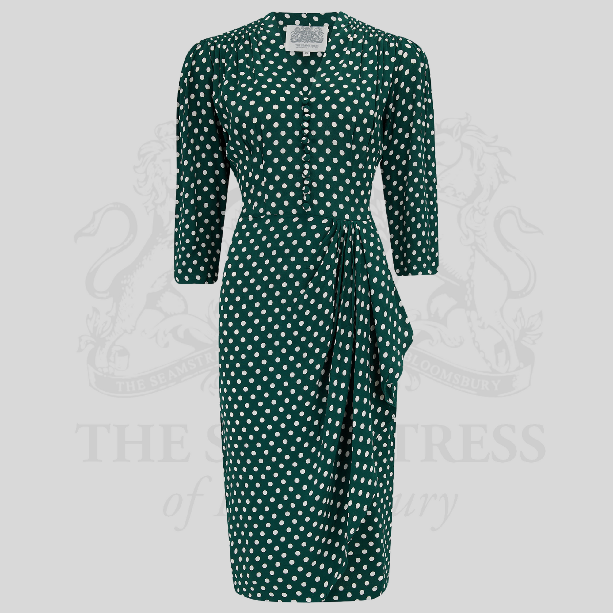 A green polka-dot dress with 3/4 length sleeves, side zip closure, and side seam pockets. 