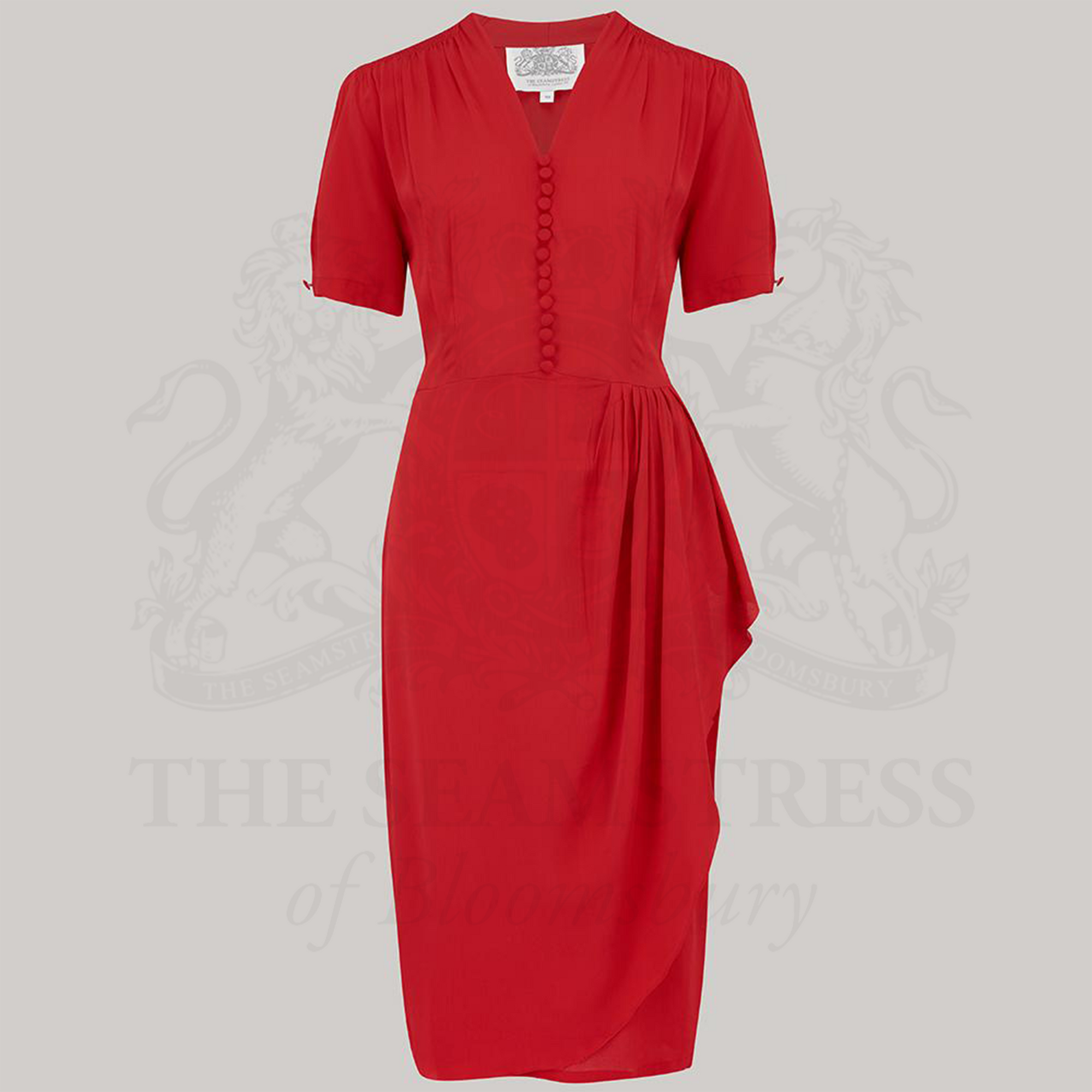 A red, short-sleeved dress with a fitted style, featuring a waterfall ruffle on the waist, decorative buttons on the front bodice, and a side zip closure.