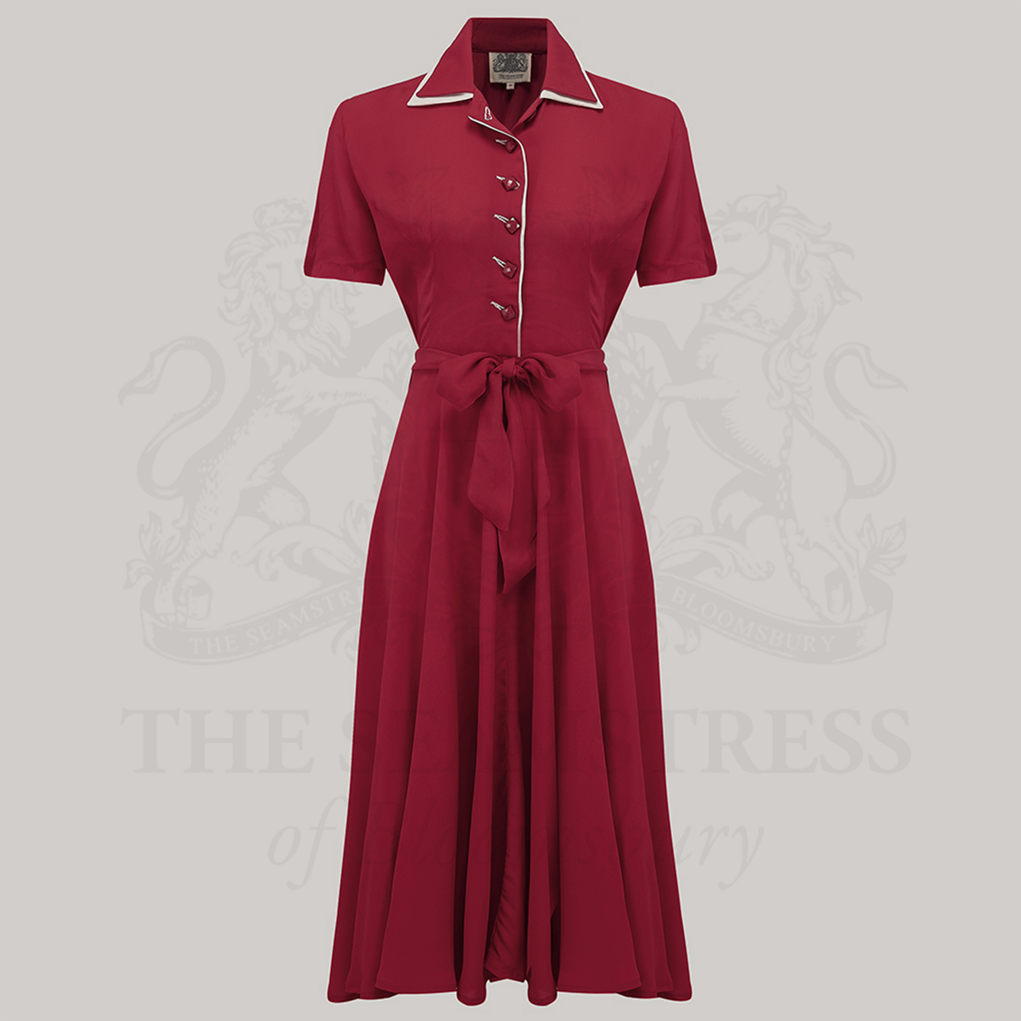 A red 1940s tea dress with square jet-style buttons and a cream undercollar