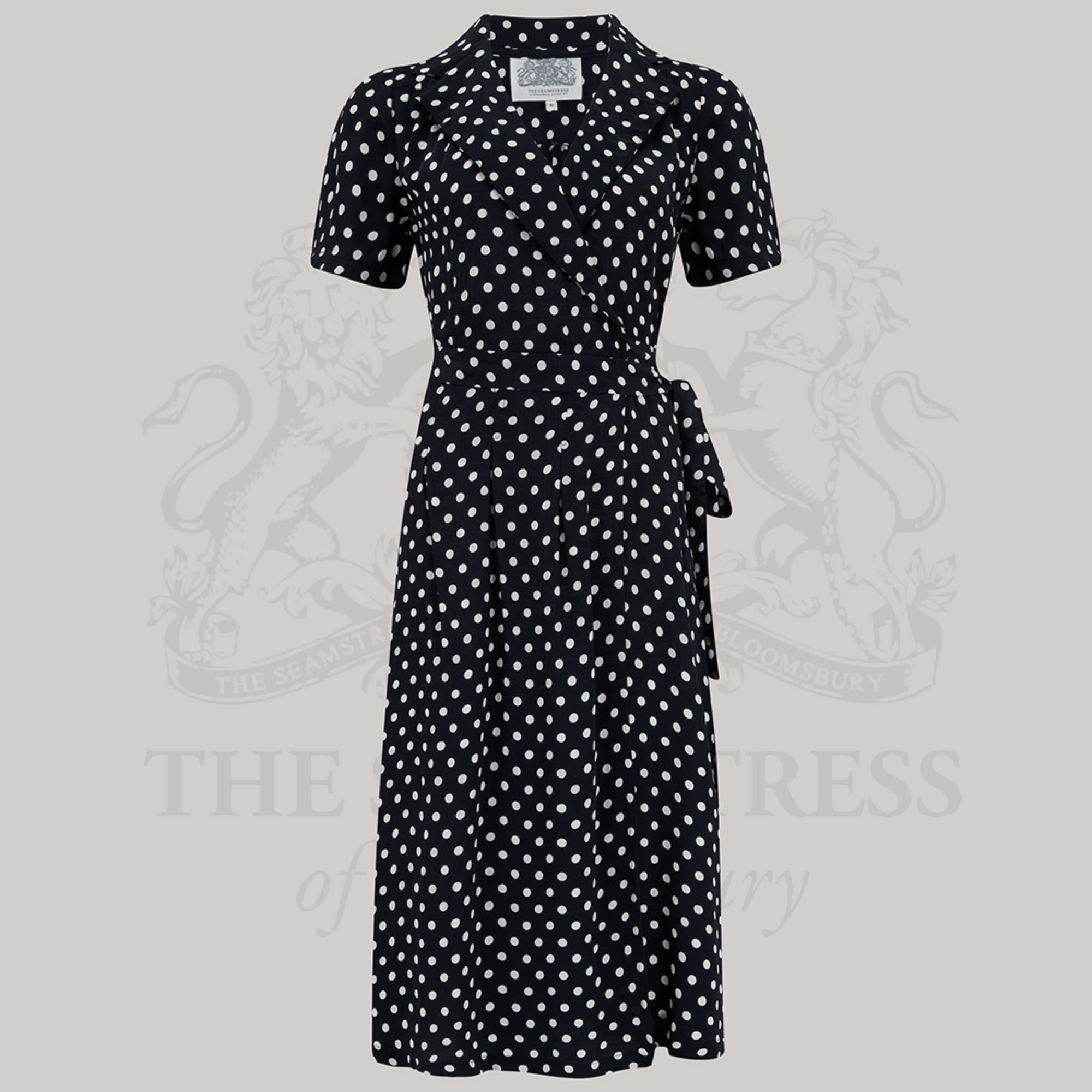 A black polka-dot dress with a v-neck and short sleeves, with side-seam pockets