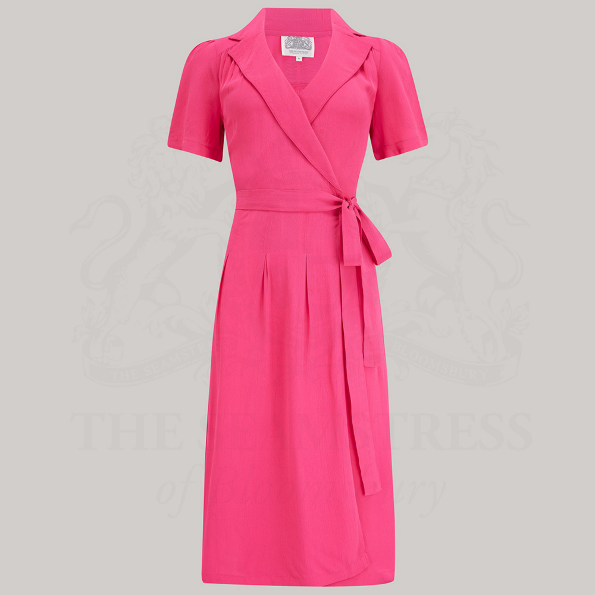 A raspberry, short-sleeved, V-neck Peggy Wrap Dress with waist tie and box pleats, with side-seam pockets.