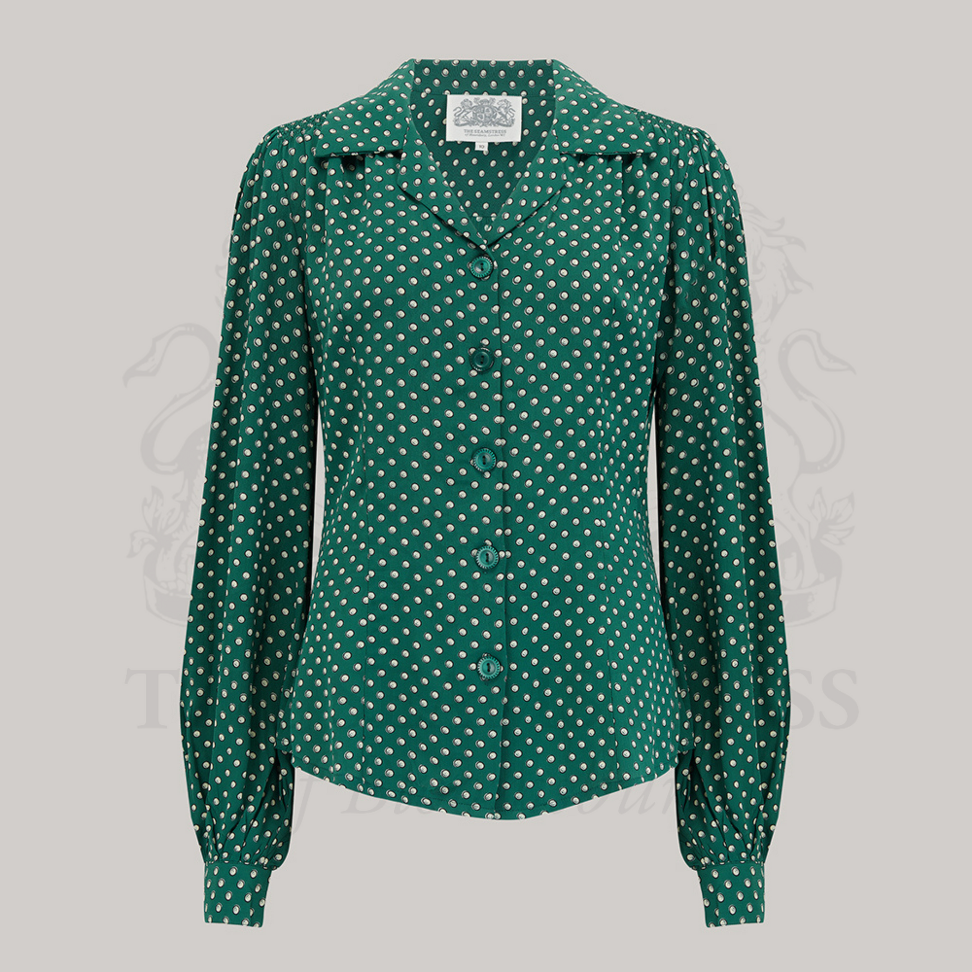 A green blouse with a revere collar, long bishop sleeves with full cuffs, and a fitted waist.