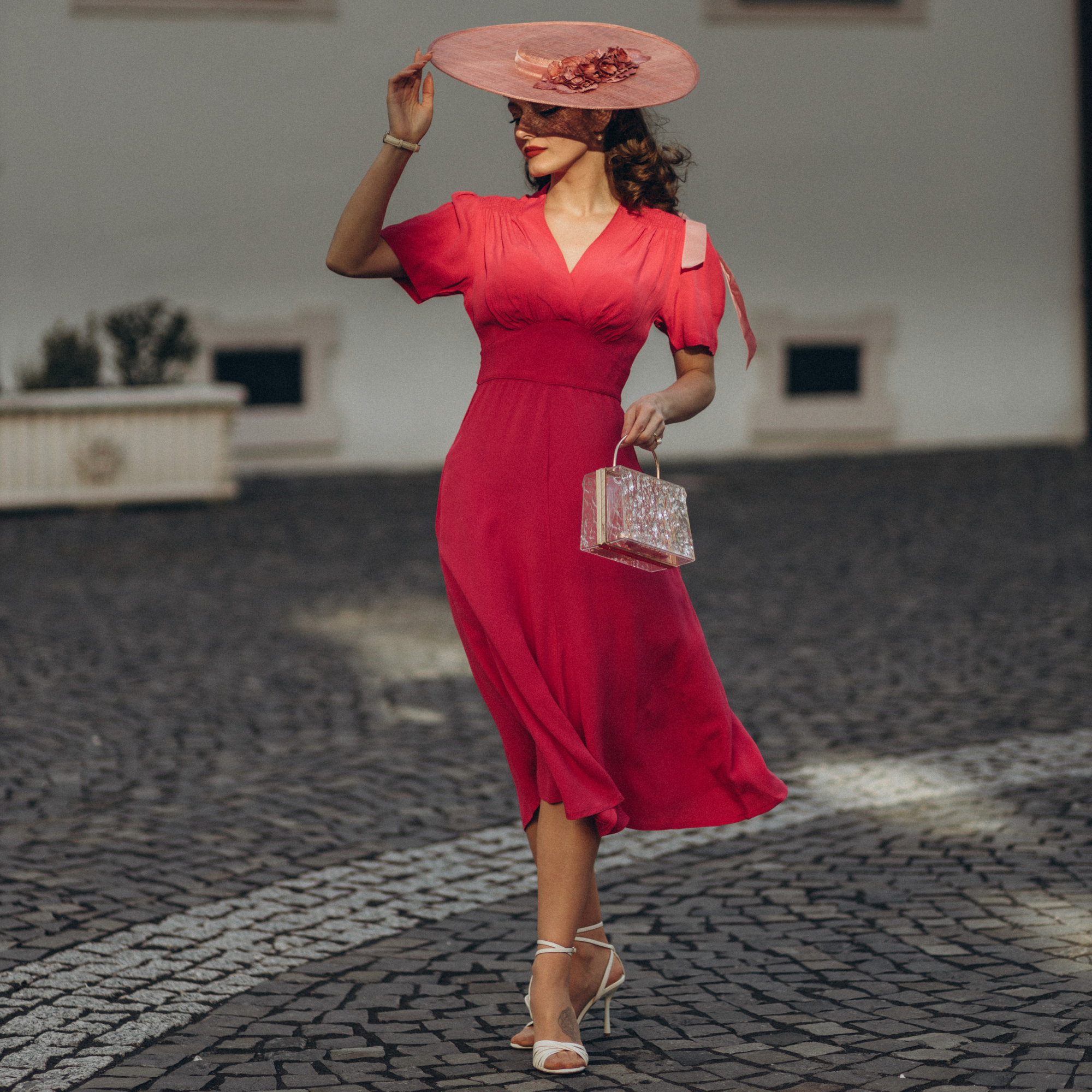 Model wears a 1940s-style raspberry pink dress and matching vintage accessories. 