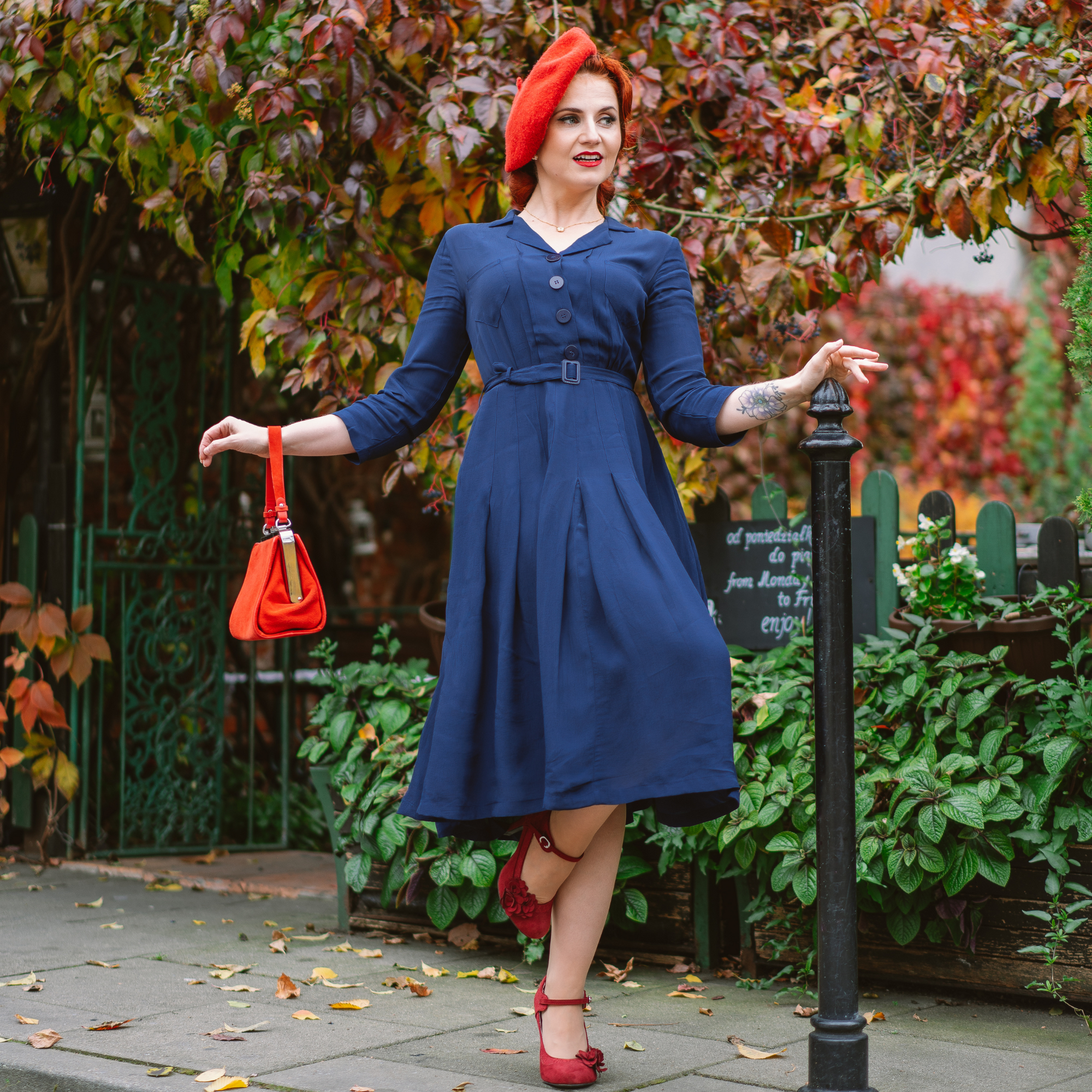 woman wearing 1940s style navy shirtwaist dress, with matching vintage accessories