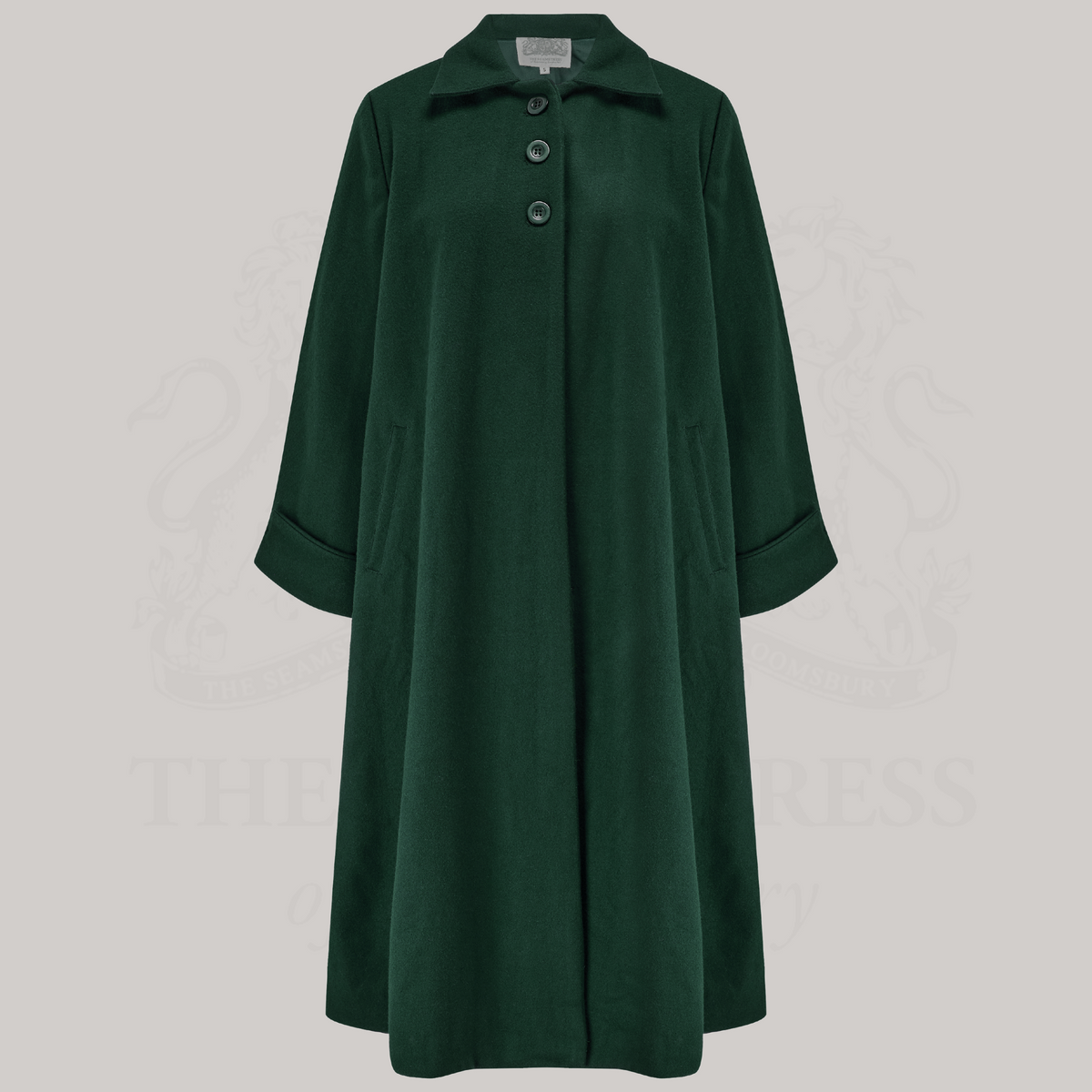 A long vintage inspired coat in dark green. The coat has 3 buttons at the top of the coat. 