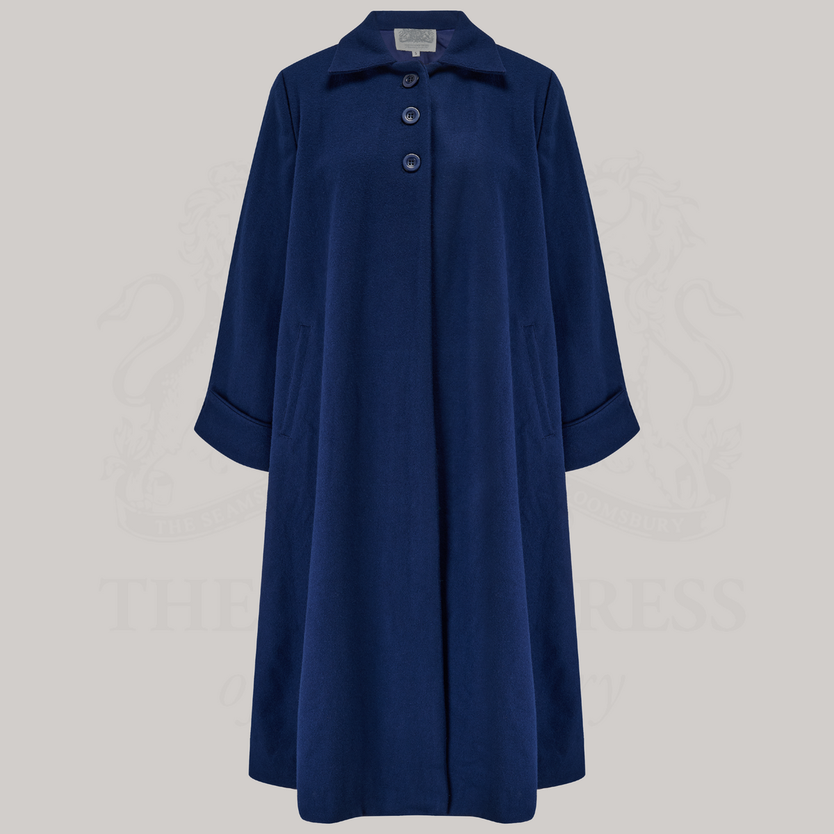 A 1940s style 43 inch long swing coat in navy. It has three buttons at the top front, small shoulder pads, and is lined in satin. 