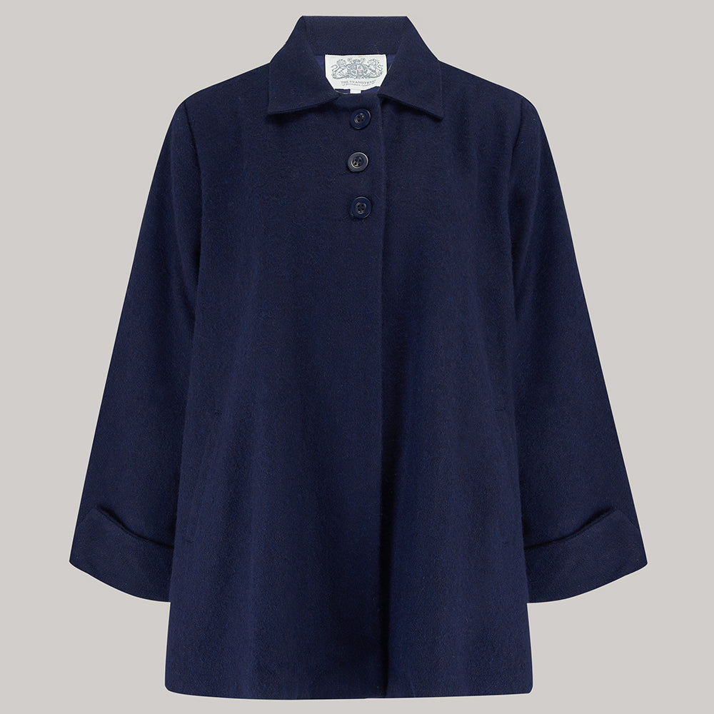 A navy swing jacket with big turn-back cuffs, three front buttons, and small shoulder pads