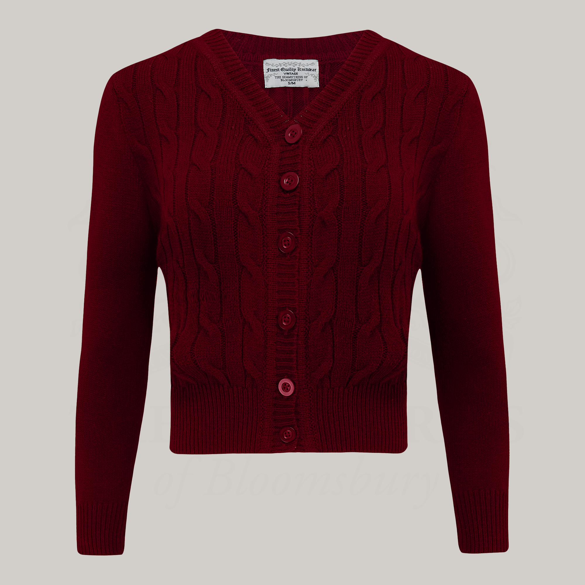 A 1940s style cable knitted cardigan in burgundy. Matching buttons feature down the front of the cardigan.