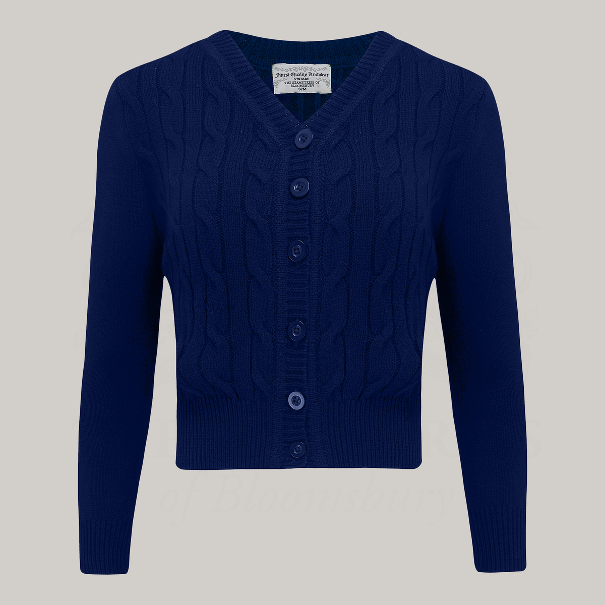 A 1940s style cable knitted cardigan in navy. Matching cream buttons feature down the front of the cardigan.