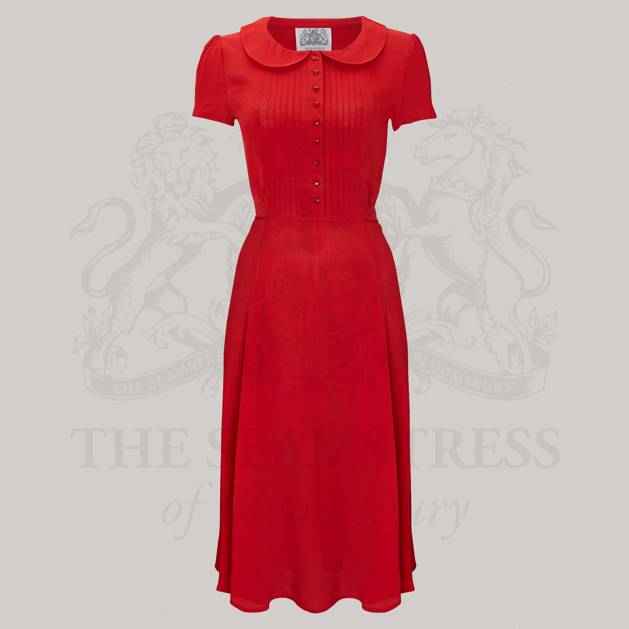 A 1940s-inspired shirtdress in red, with short sleeves and pin-tucked stitching on the bodice
