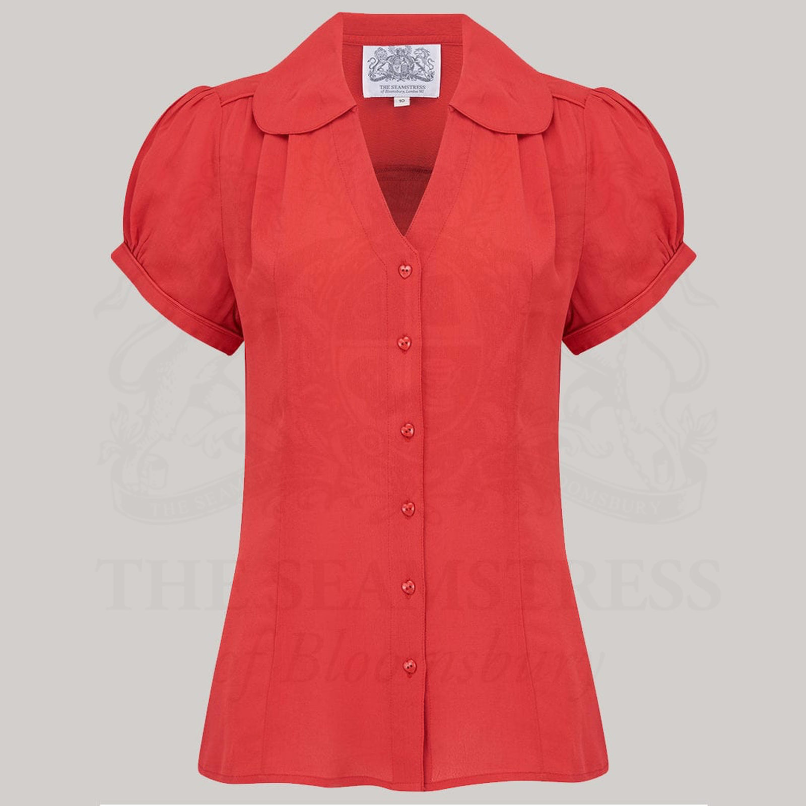 A vintage-style red blouse with a Peter Pan-style collar and puff sleeves, featuring a V-front fastening with buttons.