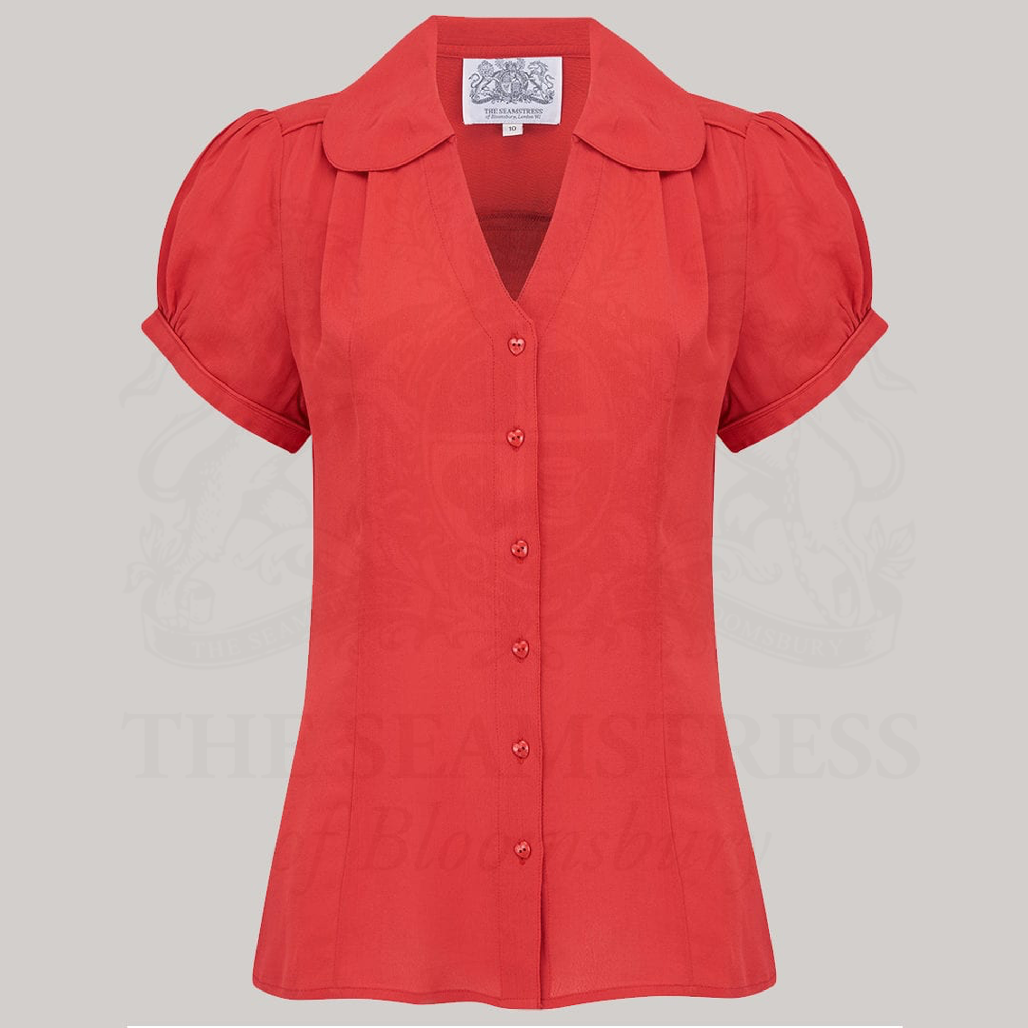 A vintage-style red blouse with a Peter Pan-style collar and puff sleeves, featuring a V-front fastening with buttons.