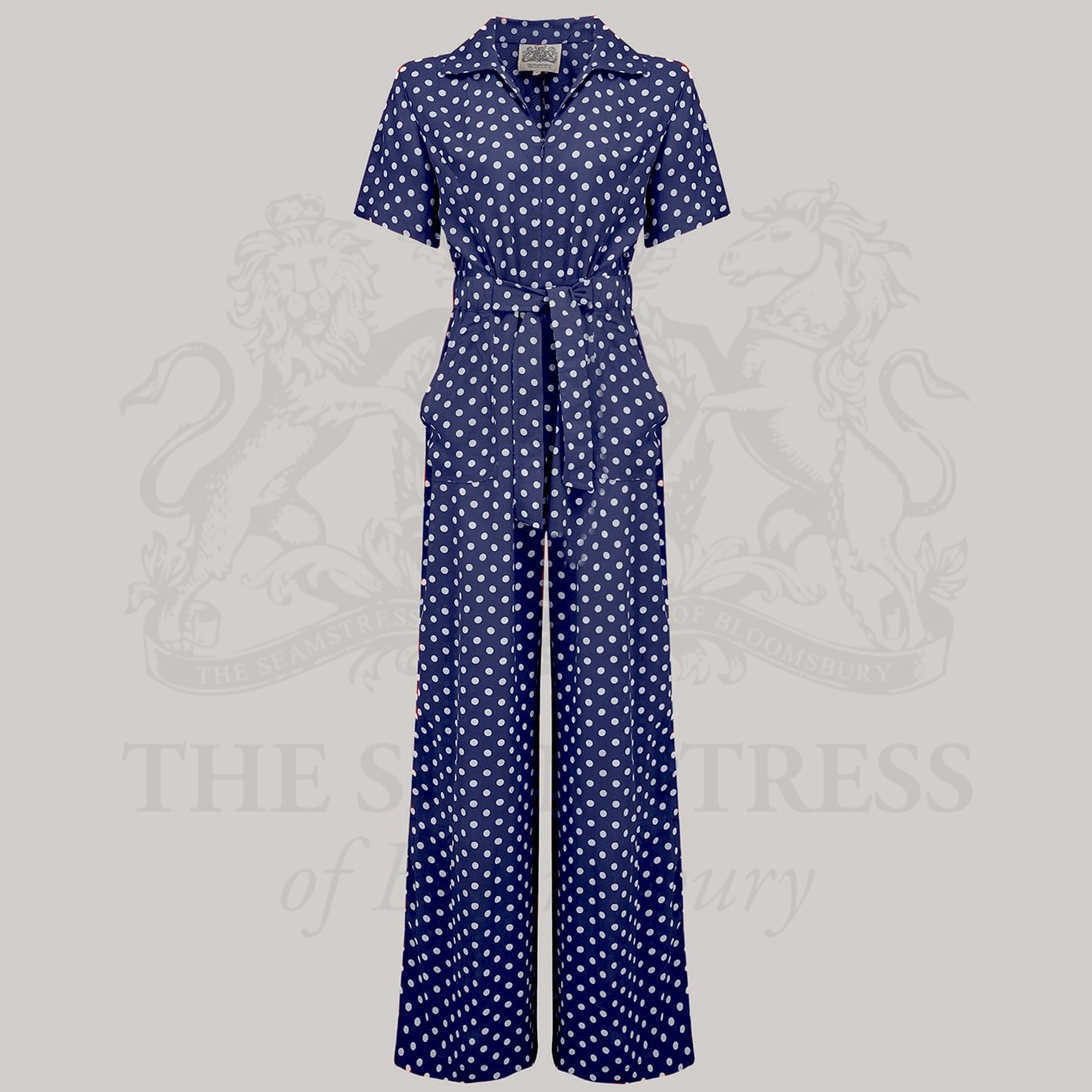 A navy siren suit with white polka dots featuring wide-leg trousers, short turn-back sleeves, and a front tie belt.