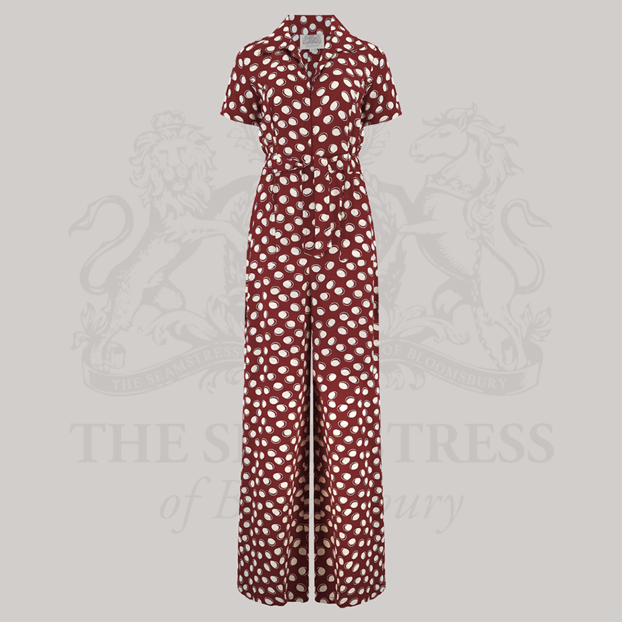 A vintage-style red and white polka dot siren suit with wide-leg trousers, short turn-back sleeves, and a tie belt at the waist.